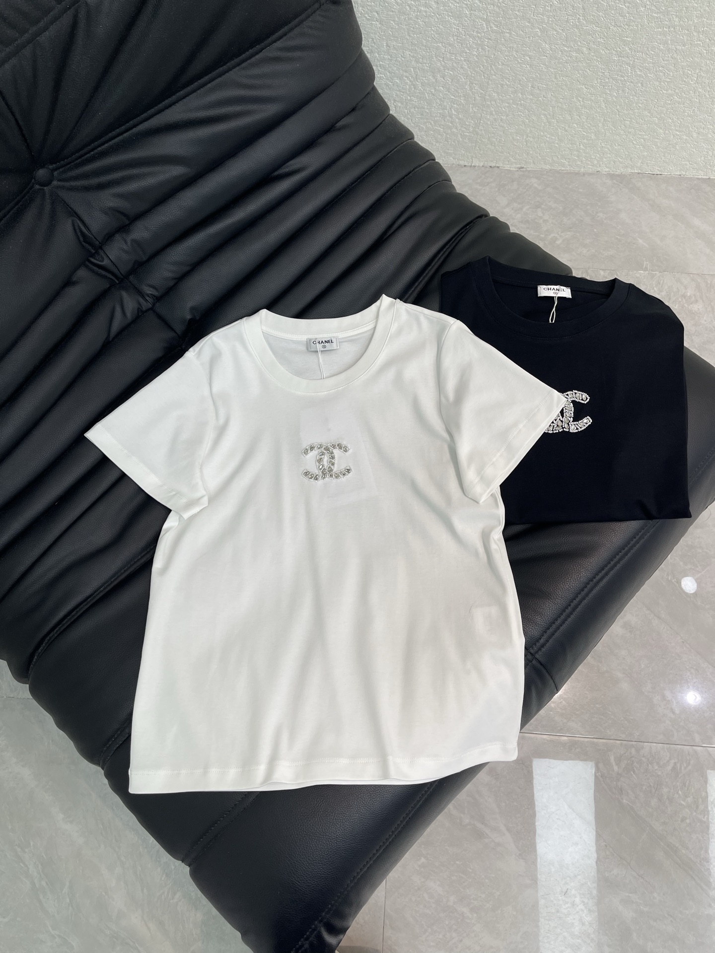 NO:790554,Chane*26 new spring and summer double C beaded round neck short-sleeved T-shirt | Exclusive high-end version!  It is made of fine and skin-friendly high-count cotton, breathable and sweat-absorbent, soft and waxy, and inlaid with handmade beads/rhinestones. It reflects the delicate luster under the light, is low-key and noble, and has a neat round neck to modify the neck line. The slightly loose tailoring is not flattering to the figure, hides the flesh and makes you slim, adapts to various body shapes, and is comfortable and comfortable for daily wear. SML A,,chanel,T-shirt,tees,t-shirt,19860909Chane*26春夏新款双C订珠圆领短袖T恤丨独家高版出品！选用细腻亲肤的高支棉,透气吸汗,软糯垂坠,手工订珠/水钻镶嵌而成,在光下折射细腻光泽,低调又显贵,利落小圆领修饰脖颈线条,微宽松剪裁不挑身材,藏肉显瘦,适配各种身形,日常穿舒适又自在.SML A,,chanel,T-shirt,tees，t-shirt,,Women's clothing