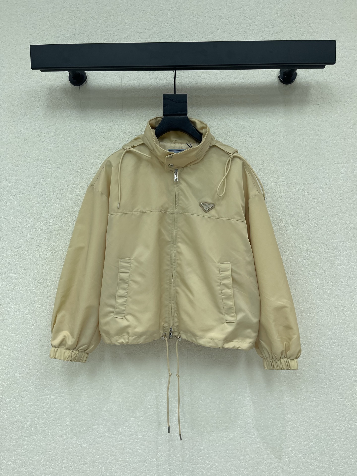 NO:793746,Prad*26 new style for early spring, triangle-labeled nylon stand-up collar jacket. The fabric is light and breathable, and the light khaki color is super versatile, perfect for spring and summer!  The stand-up collar + drawstring design is windproof and practical, and the triangular logo on the chest is very recognizable. The drawstring on the hem is adjustable, and the cuffs are elasticated, making it comfortable and neat. It can be easily controlled for daily commuting and outdoor activities. Pair it with overalls or jeans for a functional urban style!  SML,,prada,jeans,jackets & coats,jackets & coats,19860909Prad*26早春新款 三角标尼龙立领夹克外套.面料轻薄透气,浅卡其色超百搭,春夏穿超合适！立领+抽绳设计,防风又实用,胸前三角徽标超有辨识度.下摆抽绳可调节,袖口松紧收口,舒适又利落.日常通勤、户外活动都能轻松驾驭,搭配工装裤或牛仔裤,都市机能风get！SML,,prada,jeans,jackets & coats,jackets & coats,,Women's clothing