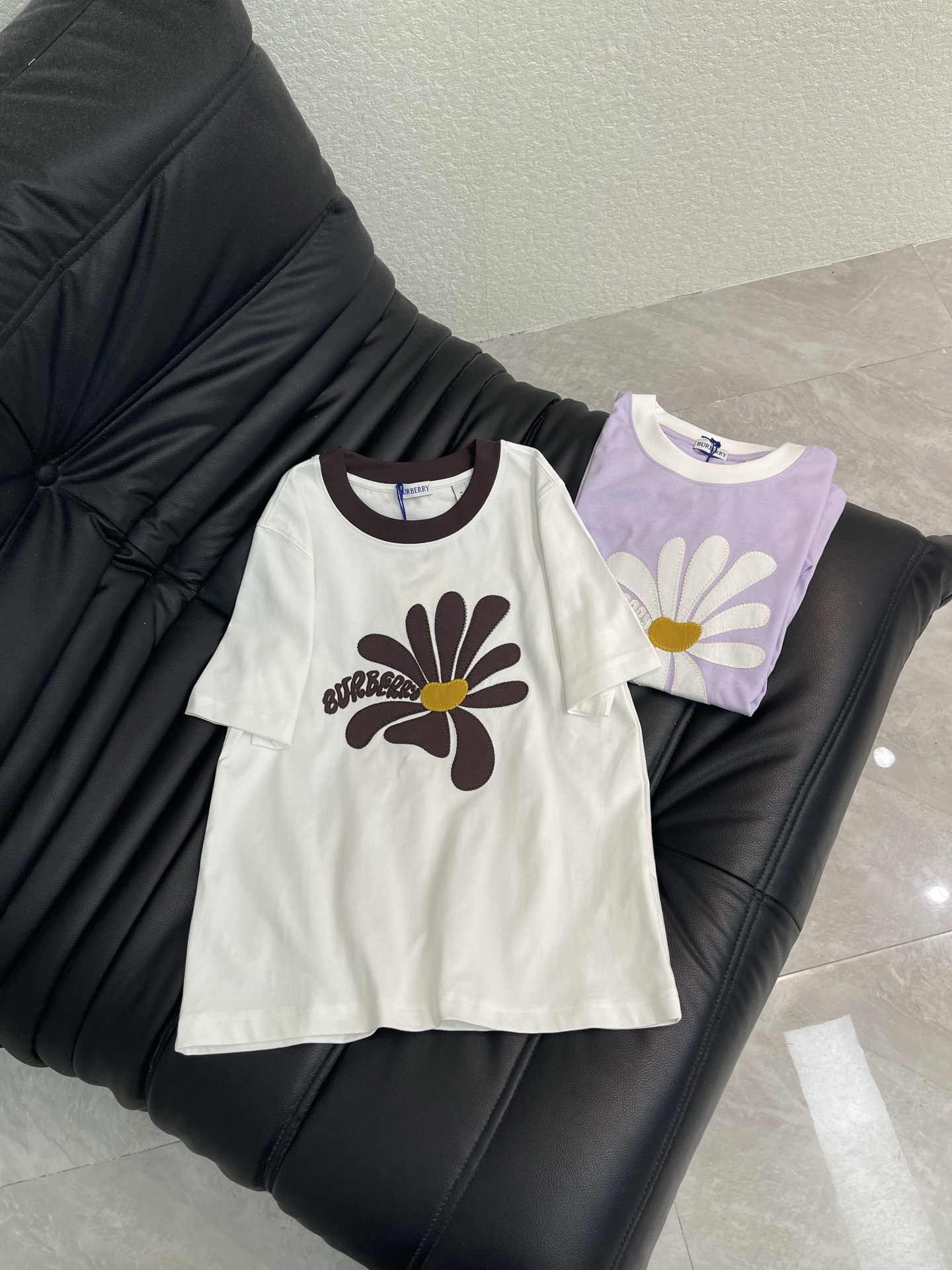 NO:793245,Burberr*26 new spring and summer daisy print T-shirt. This daisy print T-shirt is made of pure cotton, soft and comfortable, and super friendly for daily wear! White + light purple color combination, with classic daisy pattern and brand letters, simple and fashionable. Round neck design, loose fit, it is OK to wear with jeans or casual pants in spring and summer, easy to create a casual style. The label shows that it is authentic, suitable for sisters who like fashion and pursue comfort. SML,, burberry, jeans, tees, t-shirt,19860909Burberr*26春夏新款雏菊印花T恤.这款雏菊印花T恤,采用纯棉材质,柔软舒适,日常穿着超友好!白色+浅紫色配色,搭配经典雏菊图案和品牌字母,简约又时髦.圆领设计,宽松版型,春夏季节随便搭牛仔裤或休闲裤都很OK,轻松打造休闲风.标签显示为正品,适合喜欢时尚又追求舒适的姐妹们.SML,,burberry,jeans,tees，t-shirt,,Women's clothing