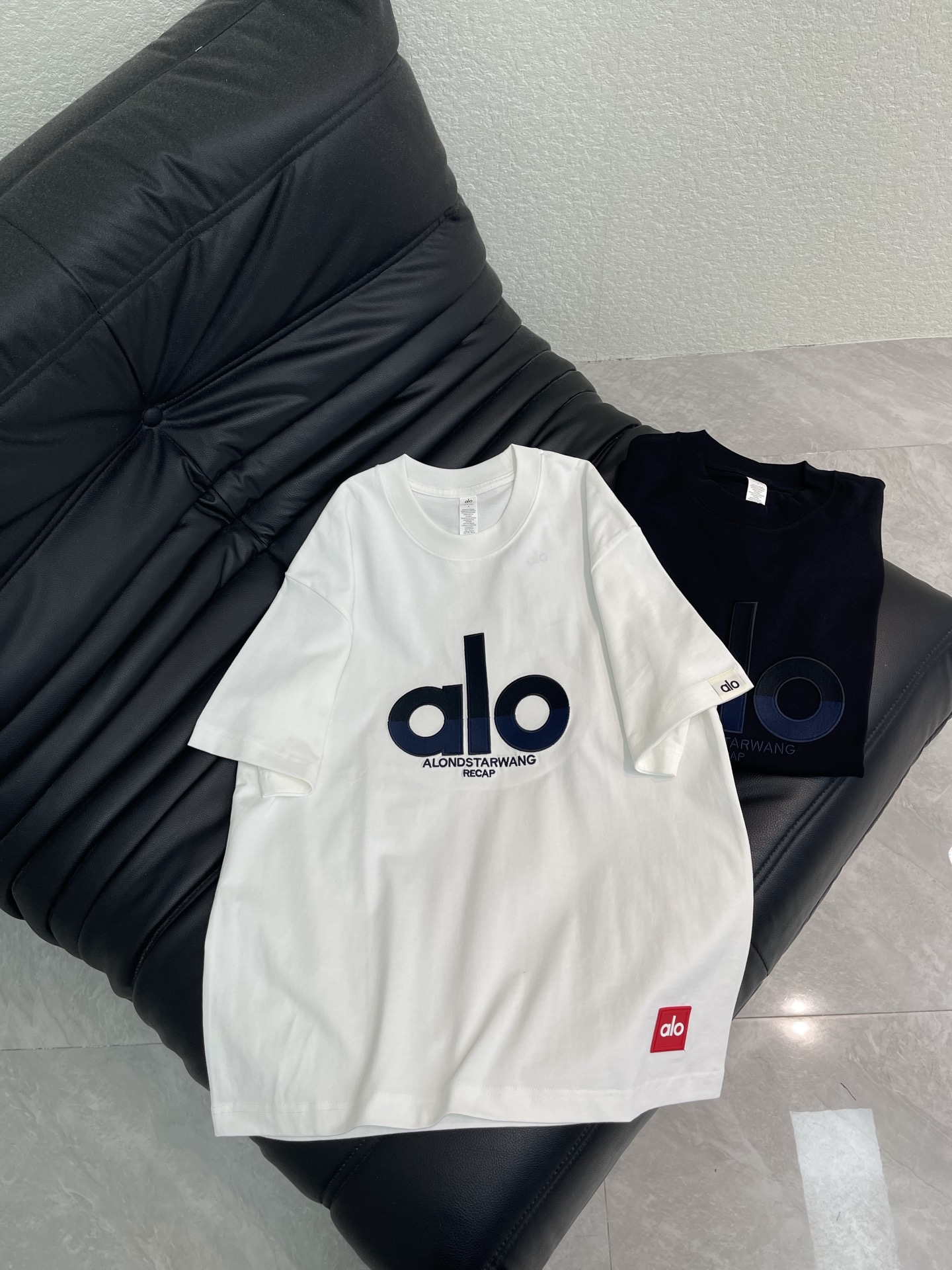 NO:792771,alo*26's new round-neck short-sleeved T-shirt with contrasting logo embroidery. The iconic red logo embossing process on the hem is full of design. Made of high-gram heavy-wash pure cotton fabric, pure cotton is breathable, very refreshing and comfortable for daily wear. The rib knitting on the neckline is smooth and tight, and the neckline will not be skewed when you toss it around. It has a loose fit and you will find that it looks really good on the upper body. The overall design is simple and neat, and it is super versatile for daily wear!  Pair it casually with one to give you a youthful look. A round neck will make your outfit go crazy. It is a fashionable item that can never go wrong!  Same style for men and women!  S-XL,,T-shirt,tees,t-shirt,19860909alo*26新款撞色logo刺绣圆领短袖T恤.下摆标志性红色标压印工艺,设计感满满.高克重洗水纯棉质面料,纯棉透气,日常穿着非常清爽穿感舒适,领口的罗纹针织平整紧密,随意折腾都不会领口歪斜,宽松版型,上身你就会发现真的好好看,整体极简利落,超级日常百搭！随随便便搭配一条就是青春的样子,一件圆领就能为你的穿搭疯狂,绝不会出错的时髦单品！男女同款！S-XL,,T-shirt,tees，t-shirt,,Women's clothing