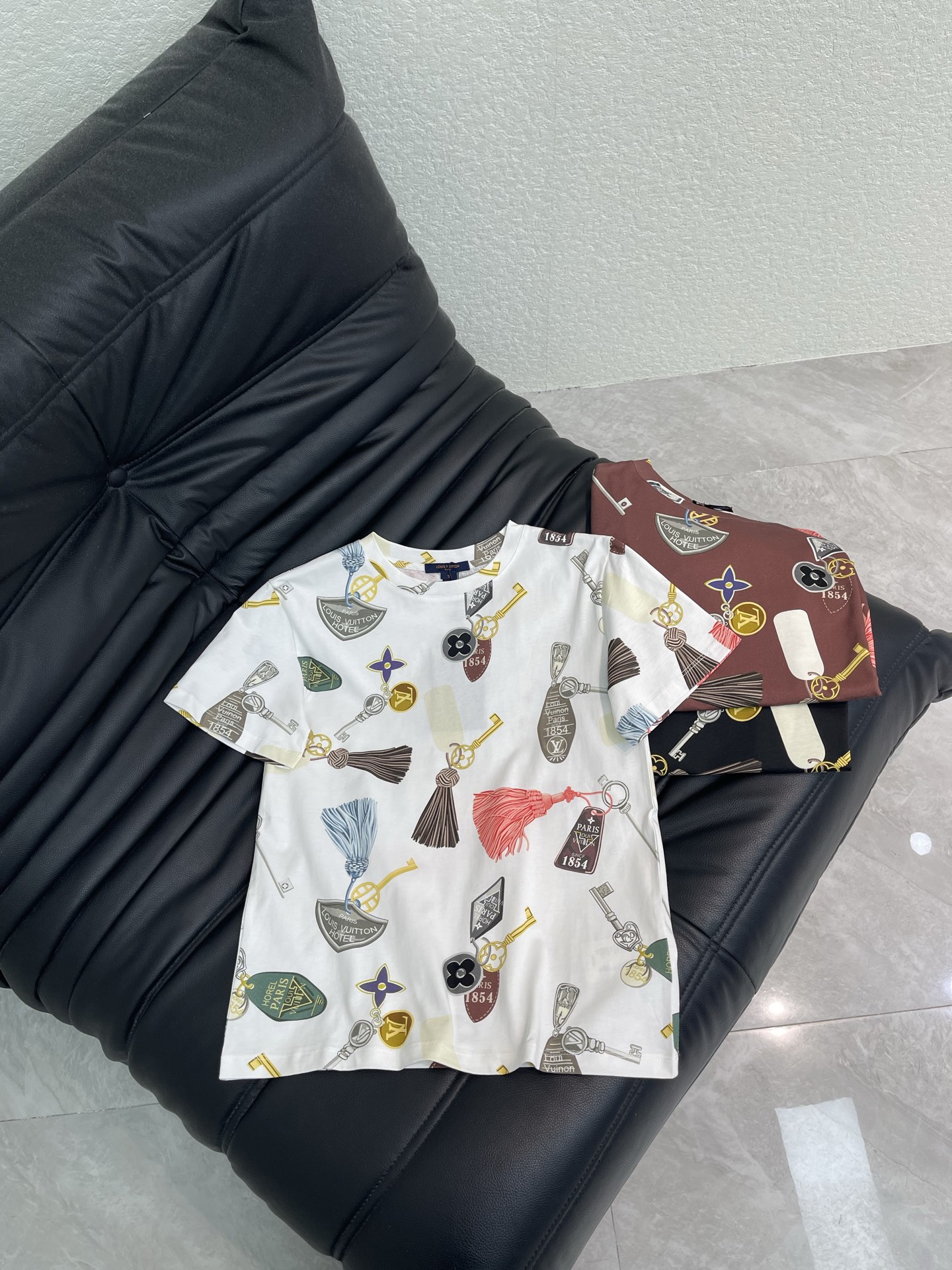 NO:793758,Louis Vuitto*26 new spring and summer printed round neck short-sleeved T-shirt. This short-sleeved shirt is printed with keys, tassels and label elements, giving it a retro and street feel!  The cotton fabric is soft and breathable, making it super comfortable for daily wear. The round neck design is simple and versatile, and available in dark brown, black, and white colors, making it easy to match with various styles of clothing. The printing details are rich, and the key and tassel patterns are super personalized!  SML A,,louis vuitton,T-shirt,tees,t-shirt,19860909Louis Vuitto*26春夏新款印花圆领短袖T恤.这款短袖以钥匙、流苏和标签元素为印花,复古又街头感十足！棉质面料柔软透气,日常穿着超舒适～圆领设计简约百搭,深棕、黑色、白色三色可选,轻松搭配各种风格服饰.印花细节丰富,钥匙和流苏图案超有个性！SML A,,louis vuitton,T-shirt,tees，t-shirt,,Women's clothing