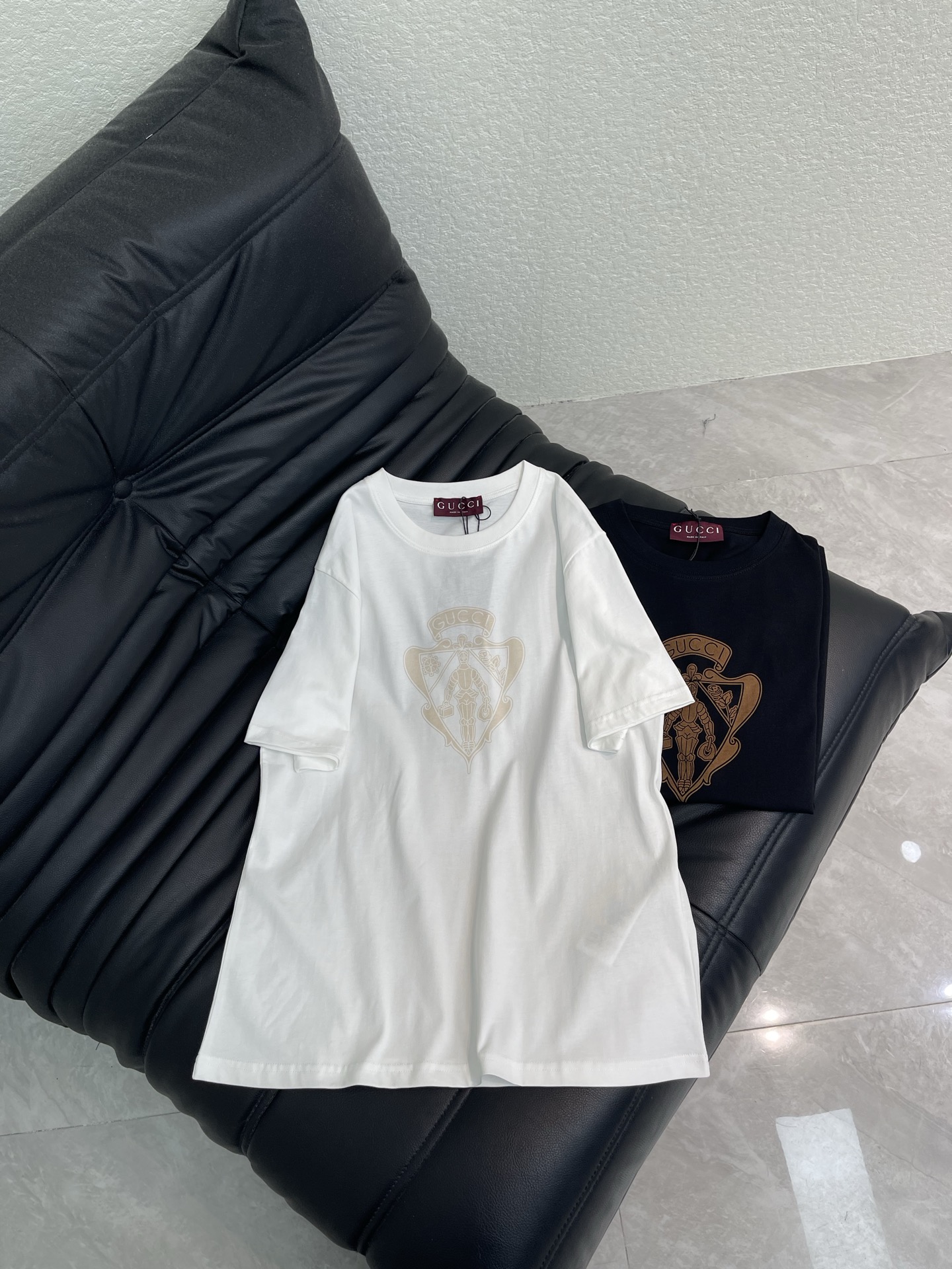 NO:794226,Gucc*26 new spring and summer shield knight letter printed round neck short-sleeved T-shirt | Exclusive high-end version!  The classic round neck and slightly loose version accommodates various body shapes and easily creates a casual and relaxed feeling. The shield-shaped knight badge on the chest adopts the same color printing process, which is delicate and three-dimensional, retro and full of recognition, and low-key declares identity. High-count cotton blended fabric is skin-friendly and breathable, with two colors of carbon black and milk white, cool and gentle can be switched with one click! SML A,, gucci, T-shirt, tees, t-shirt,19860909Gucc*26春夏新款 盾形骑士字母印花圆领短袖T恤丨独家高版出品！经典圆领微宽松版型,包容各种身形,轻松打造随性松弛感.胸口的盾形骑士徽章采用同色系印花工艺,细腻立体,复古又充满辨识度,低调宣告身份.高支棉混纺面料亲肤透气,炭黑与奶白两色选择,酷飒与温柔一键切换!SML A,,gucci,T-shirt,tees，t-shirt,,Women's clothing
