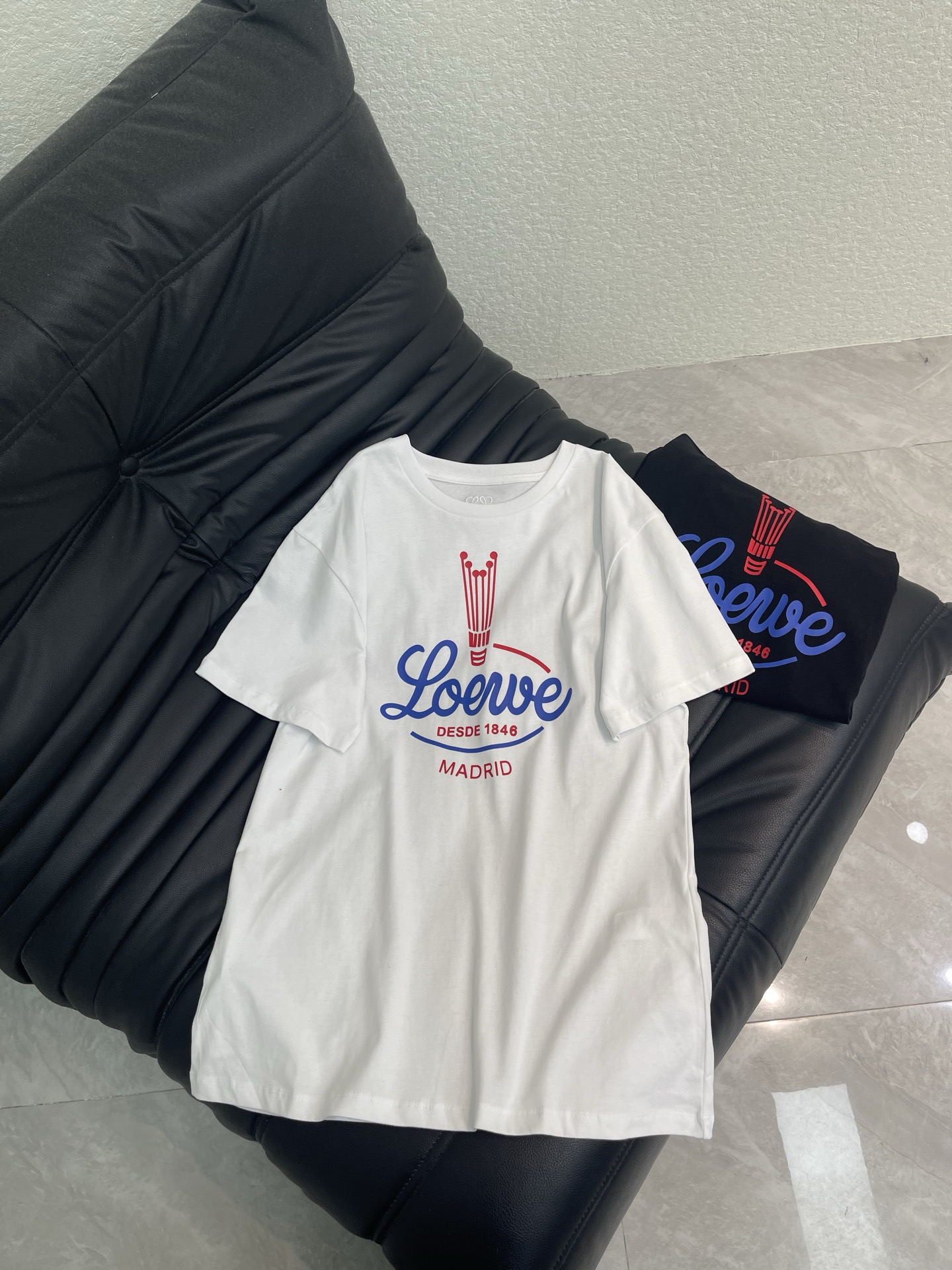 NO:797261,Loew*26's new retro American printed short-sleeved T-shirt. It can be worn in a variety of ways. It can be worn in a loose and regular fit. It contains drawstring buttons that can be buttoned to instantly change into pleated designs on both sides. The red and blue badge print on the chest really looks more and more interesting. The candlestick logo + handwritten brand name, the details are full of retro accents. The pure cotton fabric is extremely comfortable. The loose version is friendly to all body types. Paired with jeans, it is an American street style. Paired with a skirt, it will instantly become a retro lady. You can’t go wrong with black and white with your eyes closed!  SML,,loewe,skirts,jeans,T-shirt,tees,t-shirt,19860909Loew*26新款复古美式印花短袖T恤 多种穿搭方式 可宽松常规版型 内含抽绳纽扣可系扣秒变两侧褶皱设计 胸前的红蓝徽章印花真的越看越有味道,烛台标识+手写体品牌名,细节里全是复古腔调,纯棉面料巨舒服,宽松版型对各种身材都友好,搭配牛仔裤是美式街头风,配半裙又秒变复古大小姐,黑白两色闭眼入都不会错！SML,,loewe,skirts,jeans,T-shirt,tees，t-shirt,,Women's clothing