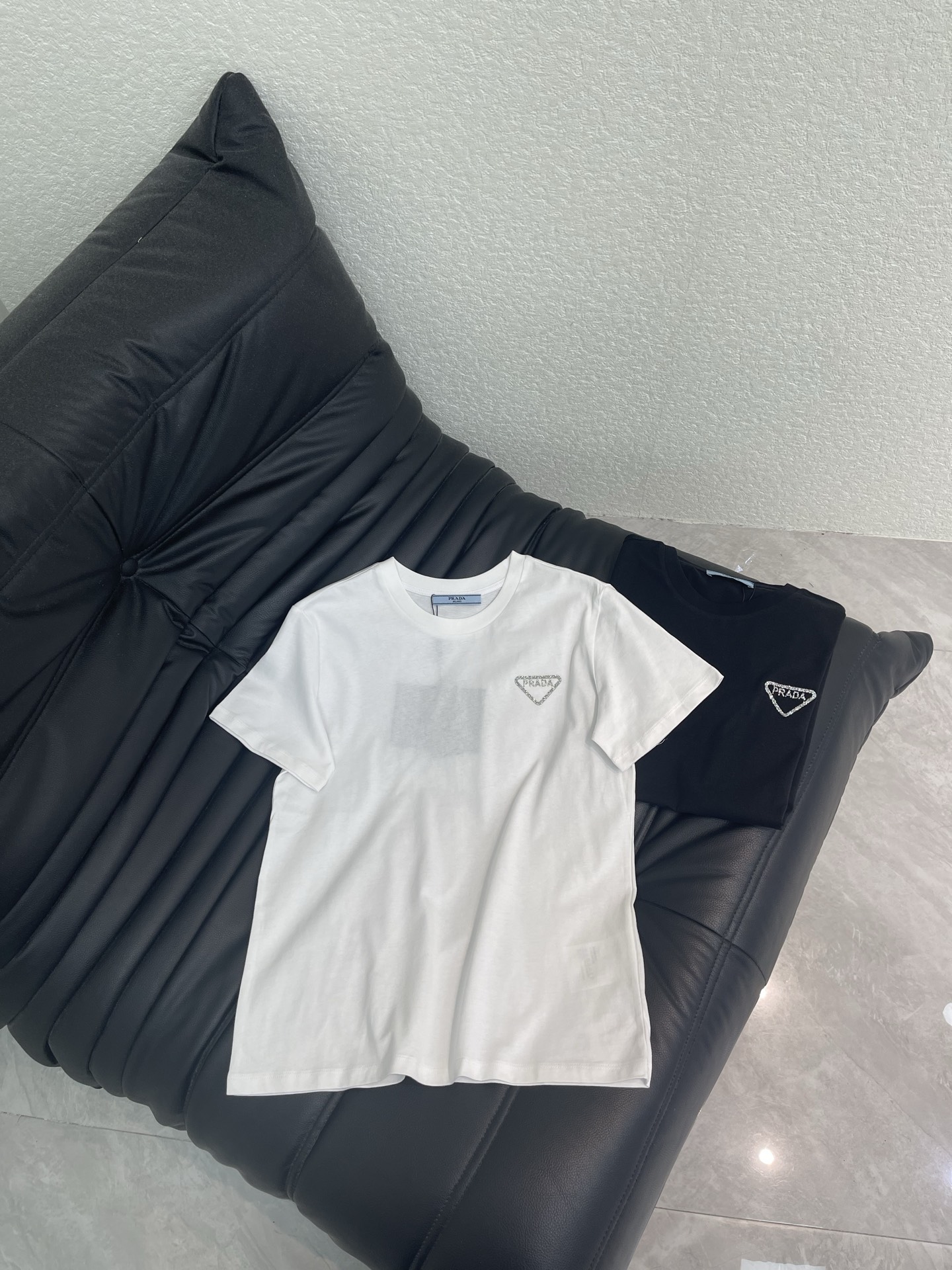 NO:797782,Prad*26 new triangular logo sparkling diamond short-sleeved T-shirt adopts a basic straight fit, not tight nor too loose, and is friendly to all body types. It is a classic T-shirt style that never goes out of style. The neckline is a standard round neck, and the lines are neatly routed. It is comfortable to wear. The silver rhinestone inverted triangle logo on the left side will refract the luster under the light. It is low-key and eye-catching. SML A,, prada, T-shirt, tees, t-shirt,19860909Prad*26新款三角标闪钻短袖T恤 采用基础直身版型 不紧绷也不过于宽松 对各种身材都很友好 是永不过时的经典 T 恤版型 领口为标准圆领 走线工整 穿着舒适不勒 左侧银色水钻倒三角 Logo 在光线下会折射光泽 低调又亮眼 SML A,,prada,T-shirt,tees，t-shirt,,Women's clothing