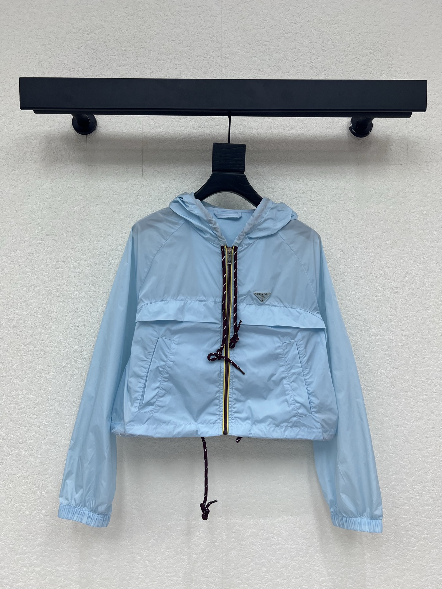 NO:799597,Prad*26 new spring and summer light blue triangle logo hooded windbreaker nylon sun protection jacket. Made of lightweight nylon material, windproof and breathable, super comfortable to wear in spring and summer!  Drawstring hood + burgundy braided rope, full of details, highly recognizable. The short cut makes you taller and slimmer, the zipper design is easy to put on and take off, and the triangle logo on the chest has a super brand feel. It can be easily controlled for daily commuting and outdoor activities, practical and fashionable, and it is a must-have and versatile item for urban girls' wardrobe!  SML A,,prada,jackets & coats,hats,19860909Prad*26春夏新款浅蓝色三角标连帽风衣尼龙防晒外套.采用轻薄尼龙材质,防风又透气,春夏穿超舒服！抽绳连帽+酒红编织绳,细节满分,辨识度超高.短款剪裁显高显瘦,拉链设计方便穿脱,胸前三角徽标超有品牌感.日常通勤、户外活动都能轻松驾驭,实用又时髦,是都市女生衣橱必备百搭单品！SML A,,prada,jackets & coats,hats,,Women's clothing