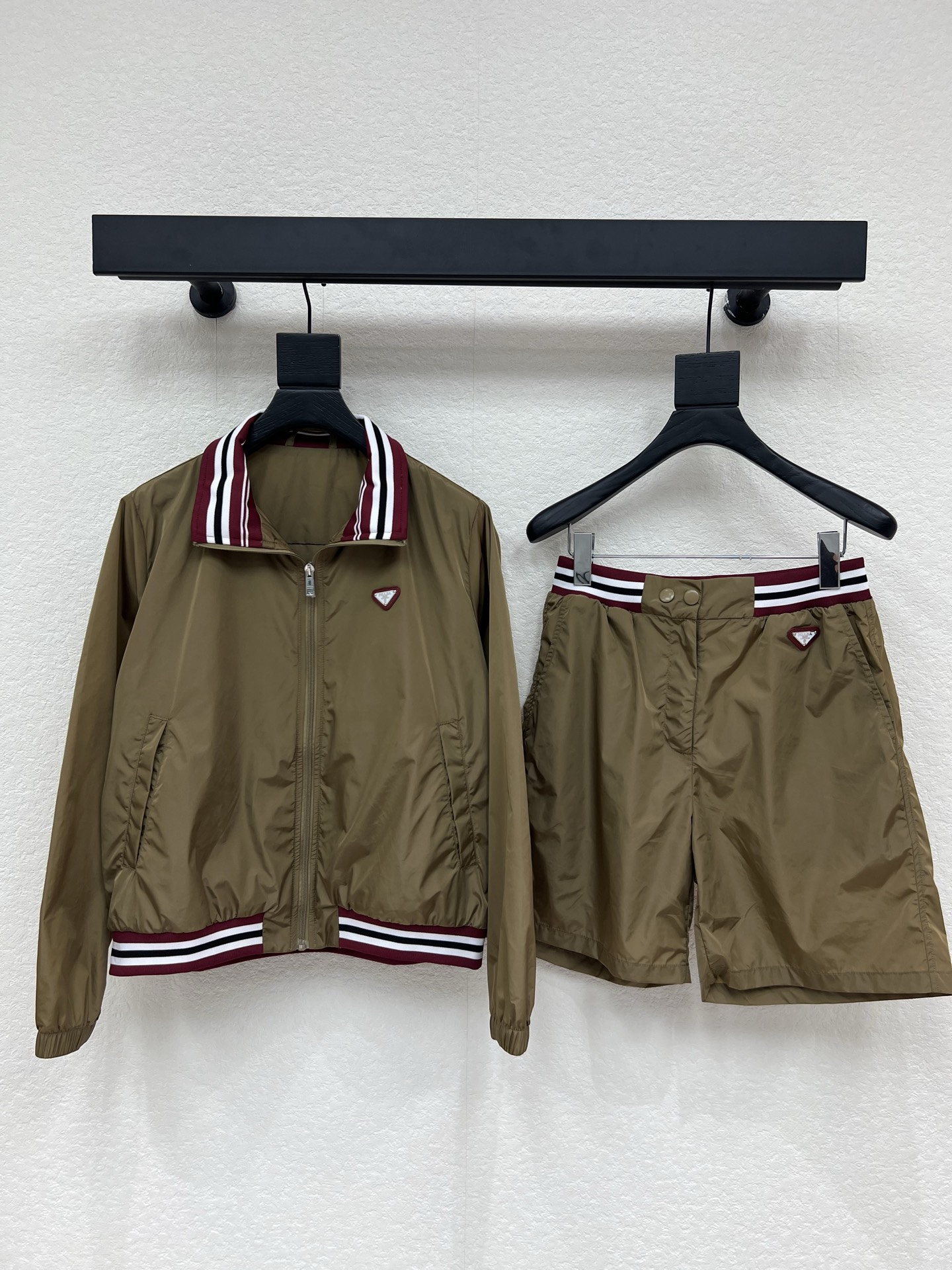 NO:802157,Jackets and shorts Prad*26 new contrasting lapel retro nylon baseball jacket + contrasting webbing nylon shorts. Brown nylon fabric is light and shiny, burgundy ribbed lapel + contrasting stripes on the hem, full of retro sporty feel!  The light blue triangle logo adds to the details of the outfit, which is very eye-catching ~ Customized imported nylon material, the inverted triangle logo is very recognizable, the jacket zipper opening + hand pockets, the mid-length pants are just right on the upper body without weighing down the body, practical and fashionable, very suitable for spring and autumn, whether it is pants or skirts, you can easily create a casual and high-end feeling, a must-have for daily outings!  SML,,prada,skirts,shorts,jackets & coats,jackets & coats,19860909外套短裤Prad*26新款撞色翻领复古尼龙棒球夹克外套+撞色织带尼龙短裤.棕黄色尼龙面料轻便有光泽,酒红罗纹翻领+下摆撞色条纹,复古运动感满满！浅蓝色三角徽标增添穿搭细节亮点,吸睛度满分～定制进口尼龙材质,倒三角徽标超有辨识度,外套拉链开合+插手口袋,中裤长度上身恰到好处不压个子,实用又时髦春秋穿超合适,无论裤装还是裙装都能轻松打造随性高级感,日常出街必备！SML,,prada,skirts,shorts,jackets & coats,jackets & coats,,Women's clothing