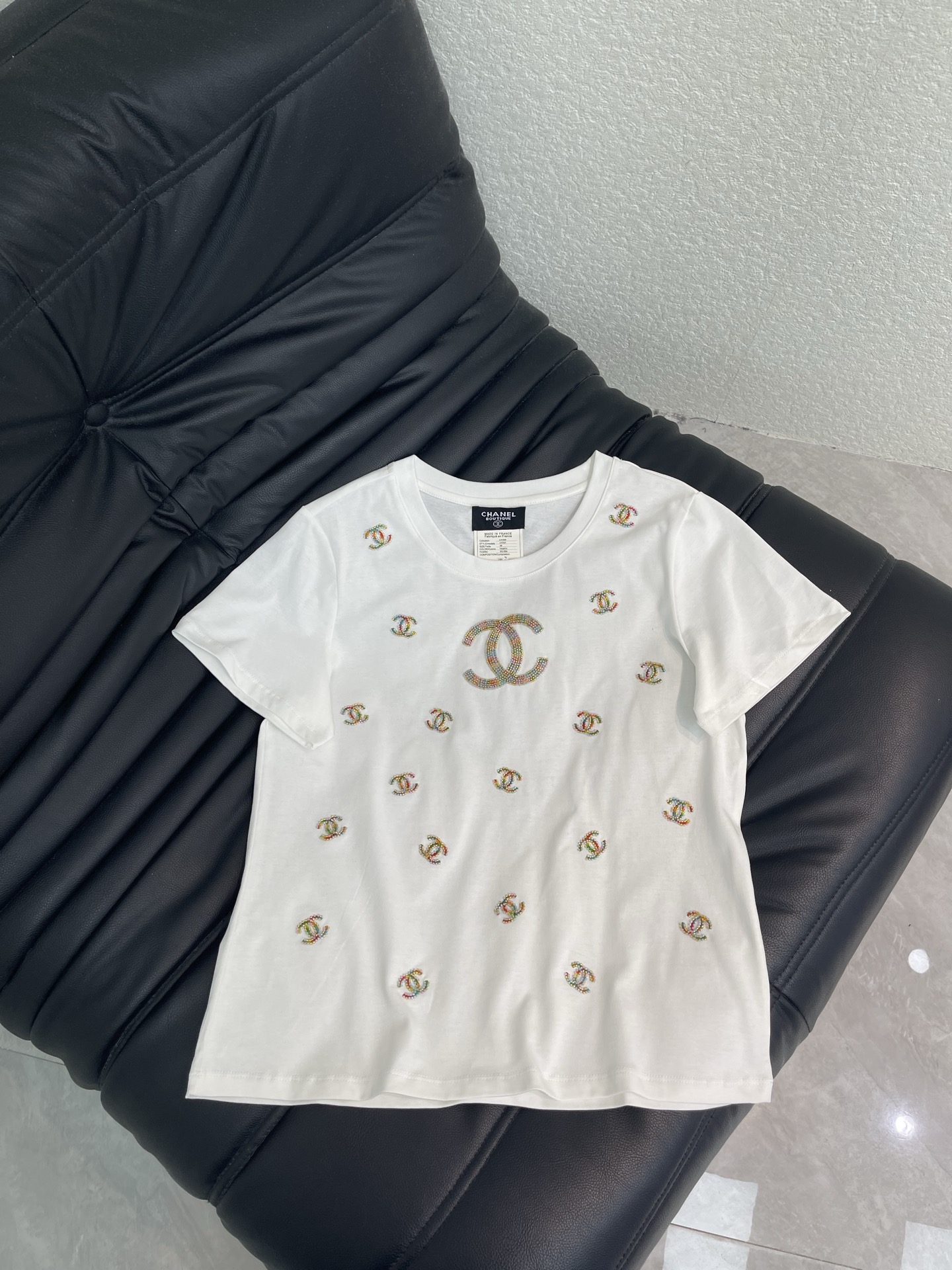 NO:808875,CHANE*26 new white heavy beaded short-sleeved T-shirt, made of soft cotton fabric, super comfortable to wear!  The ready-to-wear is embellished with colorful Double C beading embroidery, with exquisite details and perfect brand recognition. The round neck + short sleeve design is simple and versatile, and can be easily worn in daily casual wear. Whether paired with jeans or a skirt, it can easily create an elegant and casual style, making it a must-have item in the wardrobe!  SML A,,chanel,skirts,jeans,T-shirt,tees,t-shirt,19860909CHANE*26新款白色重工钉珠短袖T恤,采用柔软棉质面料,穿着超舒适！成衣点缀彩色双C钉珠刺绣,细节精致感满满,品牌辨识度满分.圆领+短袖设计,简约百搭,日常休闲都能轻松驾驭.无论配牛仔裤还是半裙,都能轻松打造优雅随性风,是衣橱必备单品！SML A,,chanel,skirts,jeans,T-shirt,tees，t-shirt,,Women's clothing