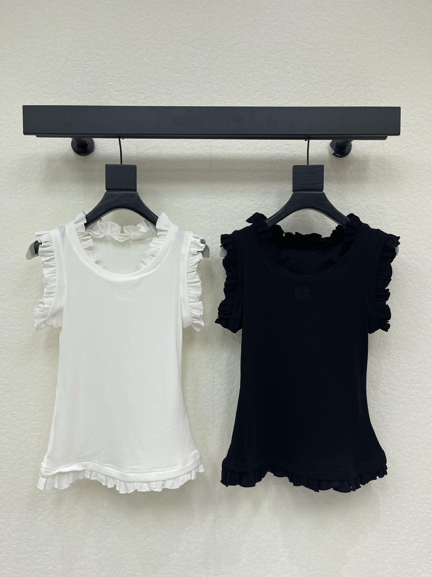 NO:838348,Loew*26 new spring and summer new ruffle vest. High elastic soft waxy rib fabric, skin-friendly, breathable and not stuffy, with soft matte texture, excellent elasticity, not tight fit on the upper body, and not easy to deform after long-term wear. Waist slim fit, neat tailoring outlines the waistline, optimizes body proportions, and easily wears a slim waist; high collar + ruffle design modifies the neckline, with a right-angled shoulder effect, making it slim and elegant. SML,, loewe,19860909Loew*26春夏新品荷叶边背心.高弹软糯罗纹面料,亲肤透气不闷汗,自带柔和哑光质感,弹力优秀,上身贴合不紧绷,久穿不易变形. 收腰修身版型,利落剪裁勾勒腰线,优化身材比例,轻松穿出小蛮腰；高领+荷叶边设计修饰颈线,自带直角肩效果,显瘦又显气质.SML,,loewe,,Women's clothing
