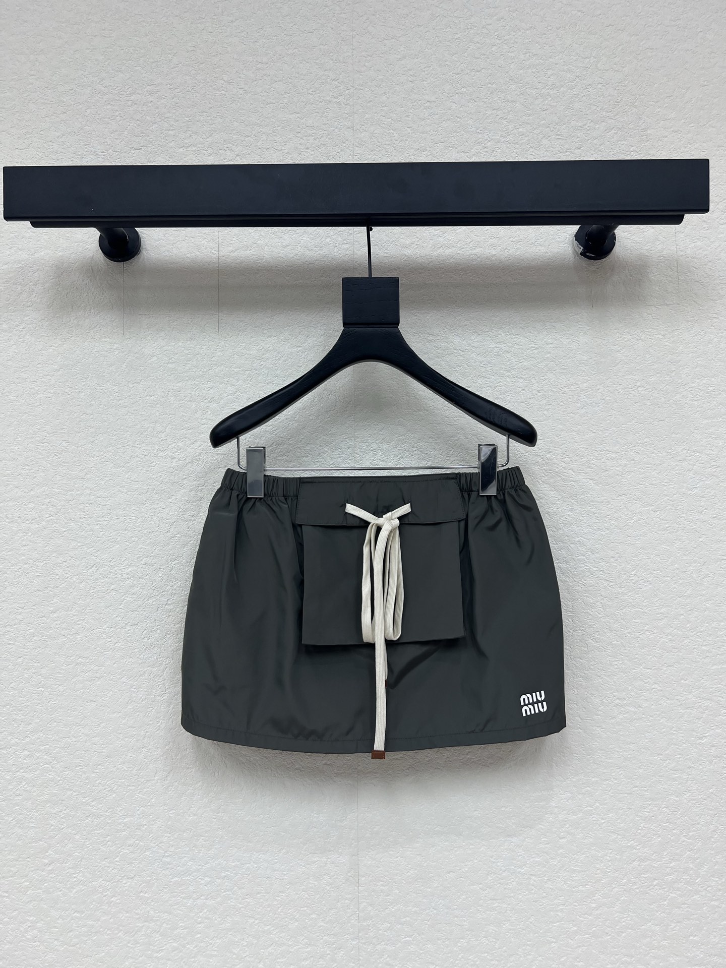 NO:839593,Miumi*26's new dark gray nylon drawstring workwear style mini skirt. The 'Y2K Retro Revival' skirt for sweet and cool girls is here. Couture nylon fabric comes with a soft light filter, dark gray tone is high-end and stain-resistant. Front large pocket + contrasting off-white drawstring, which combines the neatness and girlishness of workwear style. Low-waisted micro-A version, easy to wear a 37-point hot girl proportion. Exquisite logo printing on the side, low-key and recognizable.  Wearing a sweatshirt looks like an American campus sweet girl, and when paired with a hot girl top, she will become a god!  SML,,miumiu,hoodie,sweatshirts,skirts,19860909Miumi*26新款深灰尼龙抽绳工装风迷你半裙 甜酷少女的「Y2K复古回潮」神裙来袭 高定尼龙面料自带柔光滤镜,深灰调高级又耐脏 正面大口袋+撞色米白抽绳,把工装风的利落和少女感揉得刚刚好 低腰微A版型,轻松穿出三七分辣妹比例 侧边精致logo印花,低调又有辨识度 搭卫衣是美式校园甜妹,配辣妹上衣直接封神！SML,,miumiu,hoodie,sweatshirts,skirts,,Women's clothing