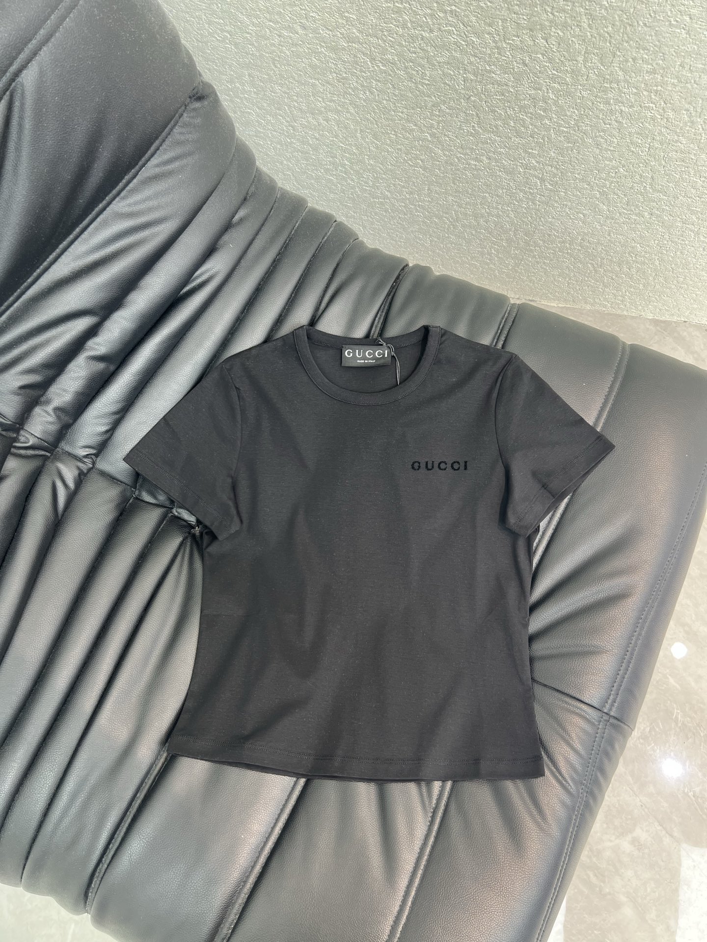 NO:840822,Gucc*26 new spring and summer classic flocked small letter short T-shirt. Black and white. Basic style can also be worn with a high-luxury texture. Selected high-count cotton fabric, soft and skin-friendly, breathable and not stuffy. Slim-fitting and slightly closed version, neat tailoring outlines smooth lines. Exquisite embroidered logo on the chest, low-key highlighting the brand tone  Versatile for everyday use, it looks elegant when worn alone or layered, and can easily adapt to a variety of scenes. Two-color SML, gucci, tees, t-shirt,19860909Gucc*26春夏新款经典植绒小字母短款T恤 黑白两色 基础款也能穿出高奢质感 甄选高支棉面料,软糯亲肤,透气不闷 修身微收版型,利落剪裁勾勒流畅线条 胸前精致刺绣标识,低调彰显品牌调性 日常百搭不出错,单穿叠穿都显贵,轻松适配多种场景.两色SML,,gucci,tees，t-shirt,,Women's clothing