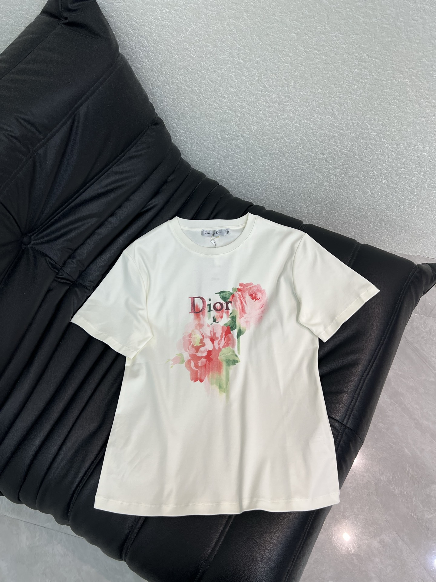 NO:843970,Dio*26 new spring and summer pink floral print short-sleeved T-shirt. Made of high-count pure cotton fabric, soft and skin-friendly, breathable and comfortable upper body, refreshing and not sweaty for daily wear. Classic round neck + fitted tailoring, neat and not flattering on the figure, pink roses on the chest with brand letter logo, low-key and full of details, with a gentle atmosphere. The basic white T is super versatile and can easily unlock a variety of styles. SML, dior, T-shirt, tees, t-shirt,19860909Dio*26春夏新款粉色花卉印花短袖T恤.采用高支纯棉面料,触感柔软亲肤,上身透气舒适,日常穿清爽不闷汗.经典圆领+合身剪裁,利落不挑身材,胸前粉色玫瑰花搭配品牌字母标识,低调又充满细节感,自带温柔氛围感.基础白T超百搭,轻松解锁多种风格.SML,,dior,T-shirt,tees，t-shirt,,Women's clothing