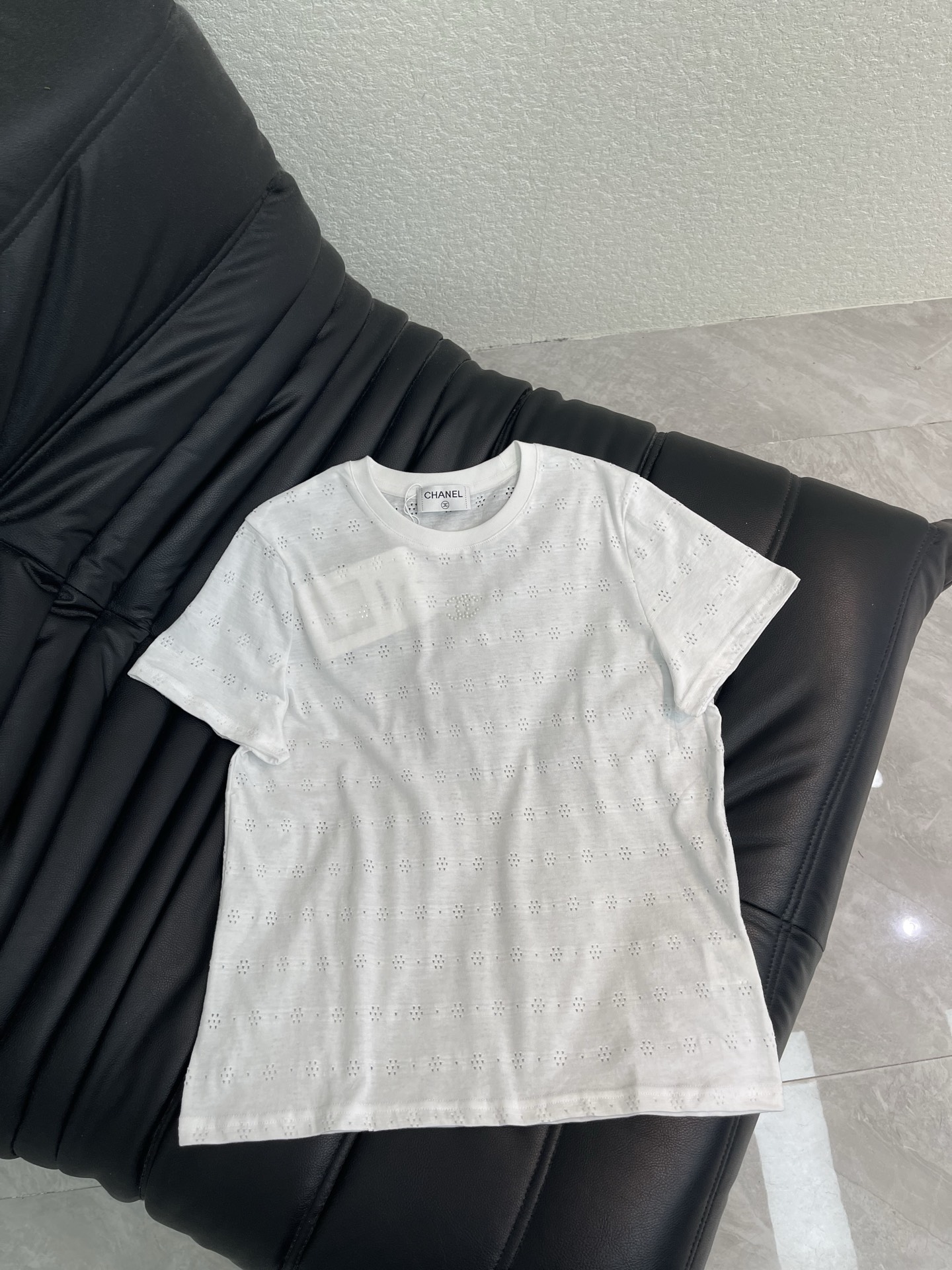 NO:861638,Chane*26 new spring and summer white hollow short-sleeved T-shirt. The cotton fabric is soft and comfortable. It is super refreshing to wear in summer. The round neck design is simple and elegant. The hollow embroidery details are exquisite. The double C logo is embellished on the shoulders. It is full of brand feeling. The M size is slim and slim. It can be easily used for daily commuting or leisure. It is versatile to wear alone or as an inner layer. It can easily create a high-end style!  Size SML,,chanel,T-shirt,tees,t-shirt,19860909Chane*26春夏新款白色镂空短袖T恤,棉质面料柔软舒适,夏天穿超清爽,圆领设计简约大方,镂空刺绣细节精致,双C Logo点缀肩部,品牌感满满,M码修身显瘦,日常通勤或休闲都能轻松驾驭,单穿或内搭都很百搭,轻松打造高级感穿搭风格！ 码数SML,,chanel,T-shirt,tees，t-shirt,,Women's clothing