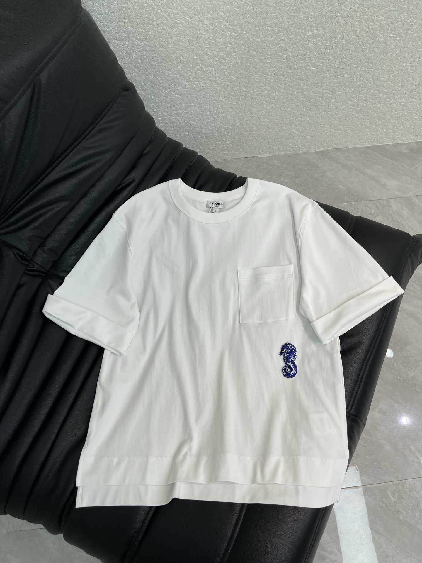 NO:861677,Chane*26 new spring and summer Coco Beach series hippocampus short-sleeved T-shirt, made of pure cotton, soft and comfortable, super refreshing to wear in summer!  The main color is white + small chest pockets, and the blue seahorse embroidery has a super ocean atmosphere. The loose fit is OK with casual pants and jeans, and can be easily worn for daily outings or vacations. The Coco Beach series focuses on summer resort style, and this T-shirt is one of the most popular items this season!  SML,,chanel,jeans,T-shirt,tees,t-shirt,19860909Chane*26春夏新款 Coco Beach系列海马短袖T恤,纯棉材质,柔软舒适,夏天穿超清爽！白色主色+胸前小口袋,蓝色海马刺绣超有海洋氛围感.宽松版型,随便搭休闲裤、牛仔裤都很OK,日常出街或度假都能轻松驾驭.Coco Beach系列主打夏日度假风,这件T恤是本季超受欢迎的单品之一！SML,,chanel,jeans,T-shirt,tees，t-shirt,,Women's clothing