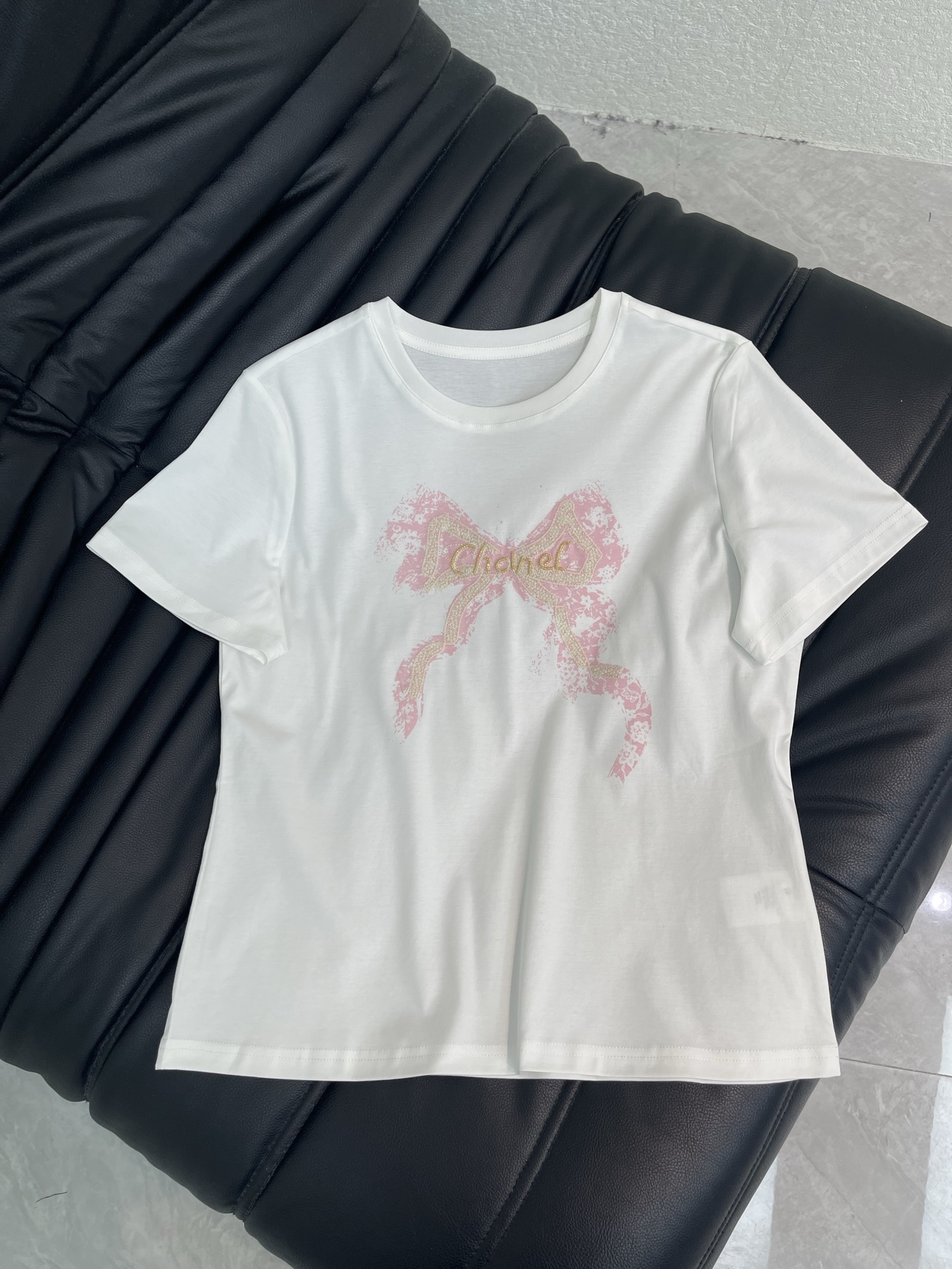 NO:875906,Chane*26 new spring and summer new bow printed embroidered beaded letter short-sleeved T-shirt. This white short-sleeved T-shirt has a pink bow + gold letter beaded logo on the front, giving it a girly look!  The pure cotton material is soft and breathable, making it super comfortable to wear in spring and summer. It has a loose fit and is very tolerant. It looks good with skirts and jeans, and it can easily switch between sweet or casual style. It can be easily used for daily outings and parties, fashionable and versatile!  SML,,chanel,skirts,jeans,T-shirt,tees,t-shirt,19860909Chane*26春夏新款蝴蝶结印花刺绣订珠字母短袖T恤.这款白色短袖T恤,正面粉色蝴蝶结+金色字母串珠Logo,少女感满满！纯棉材质柔软透气,春夏穿超舒服～宽松版型,包容性强,随便搭半裙、牛仔裤都好看,轻松切换甜美or休闲风.日常出街、聚会都能轻松驾驭,时髦又百搭！SML,,chanel,skirts,jeans,T-shirt,tees，t-shirt,,Women's clothing