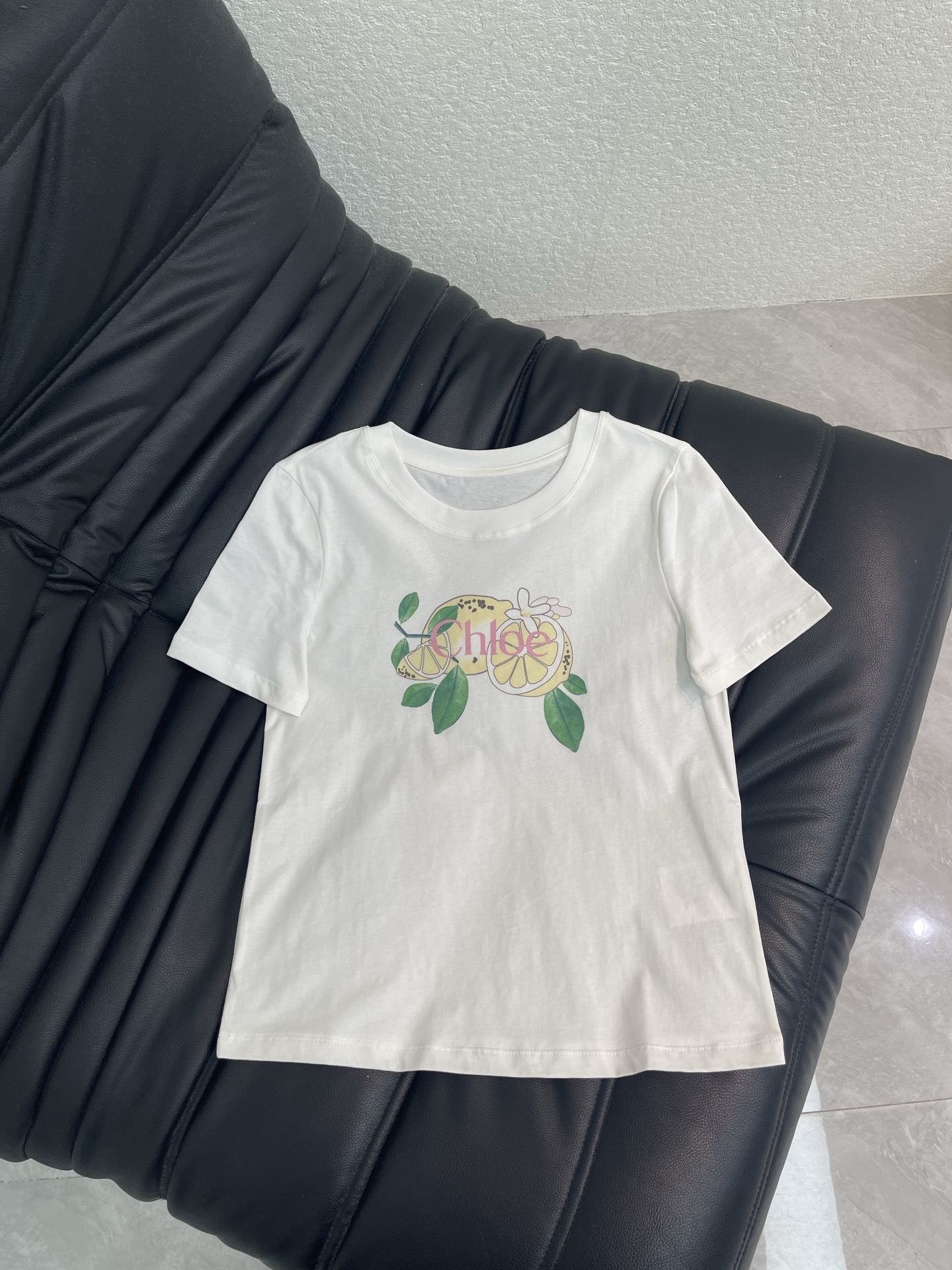 NO:884791,Chloé 26 spring and summer series lemon print short-sleeved T-shirt, classic round neck tailoring, regardless of body shape or skin color, the lemon print on the chest brings summer vitality, paired with a retro denim skirt, it has the relaxed feeling of a southern French manor, casual and advanced, paired with a khaki slim skirt, it is a gentle aura of urban women, elegant and not artificial SML,,chloe,skirts,T-shirt,tees,t-shirt,19860909Chloé 26春夏系列柠檬印花短袖T恤,经典圆领剪裁,不挑身材不挑肤色,胸前的柠檬印花自带夏日生机,搭配复古牛仔大摆裙,是南法庄园的松弛感,随性又高级搭配卡其色修身半裙,是都市女性的温柔气场,优雅不刻意 SML,,chloe,skirts,T-shirt,tees，t-shirt,,Women's clothing