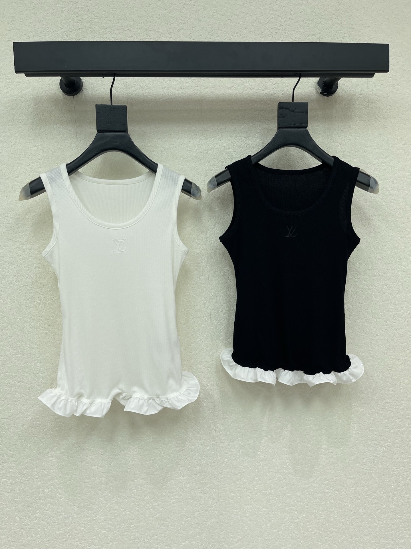 NO:886328,Louis Vuitto*26 new spring and summer ruffled vest, soft knitted fabric, super comfortable to wear!  The ruffle design on the hem is full of girlishness, and the logo embroidery on the chest is very recognizable. The sleeveless round neck is very versatile for wearing alone or layered in summer, and can be easily used for commuting and vacation ~ The black and white color scheme is classic, no matter how you match it, it is a practical and fashionable must-have item!  2 colors SML,,louis vuitton,19860909Louis Vuitto*26春夏新款荷叶边背心,柔软针织面料,穿着超舒适！下摆荷叶边设计,少女感满满,胸前logo刺绣超有辨识度.无袖圆领,夏天单穿或内搭都很百搭,通勤、度假都能轻松驾驭～黑白配色经典,怎么搭都不出错,是实用又时髦的必备单品！2色SML,,louis vuitton,,Women's clothing