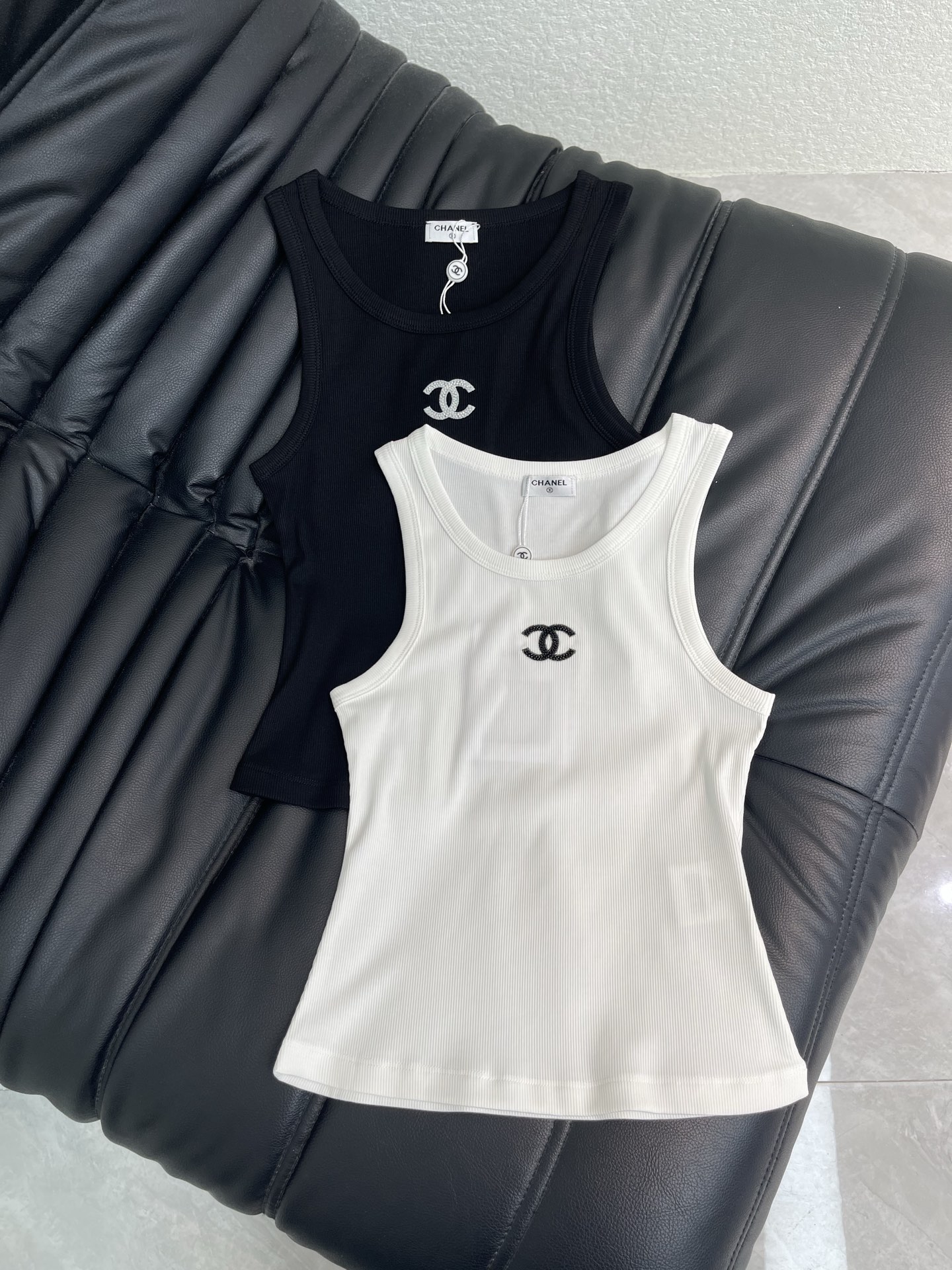 NO:893044,Chanel*26 spring and summer new heavy-duty beaded embroidery vest. It is a must-have inner layer for summer with its own luxurious filter. The classic ribbed stretch fabric is slim and not tight, and the upper body can transform into an hourglass figure in an instant. The beaded brand logo on the chest has a low-key and exquisite luster. Black and white are the king of all-match in the wardrobe. Wearing it alone is hot girl style, layering a suit or cardigan is intellectual and elegant. Wearing multiple clothes can guarantee your matching throughout the summer!  SML,,chanel,business suit,19860909Chanel*26春夏新款重工订珠刺绣背心.自带贵气滤镜的夏日刚需内搭 经典罗纹弹力面料修身不勒肉,上身秒变沙漏型身材. 胸前的钉珠品牌logo,低调闪着精致光泽,黑白两色都是衣柜里的百搭王. 单穿是辣妹风,叠穿西装、开衫又是知性优雅,一衣多穿承包你整个夏天的搭配！SML,,chanel,business suit,,Women's clothing