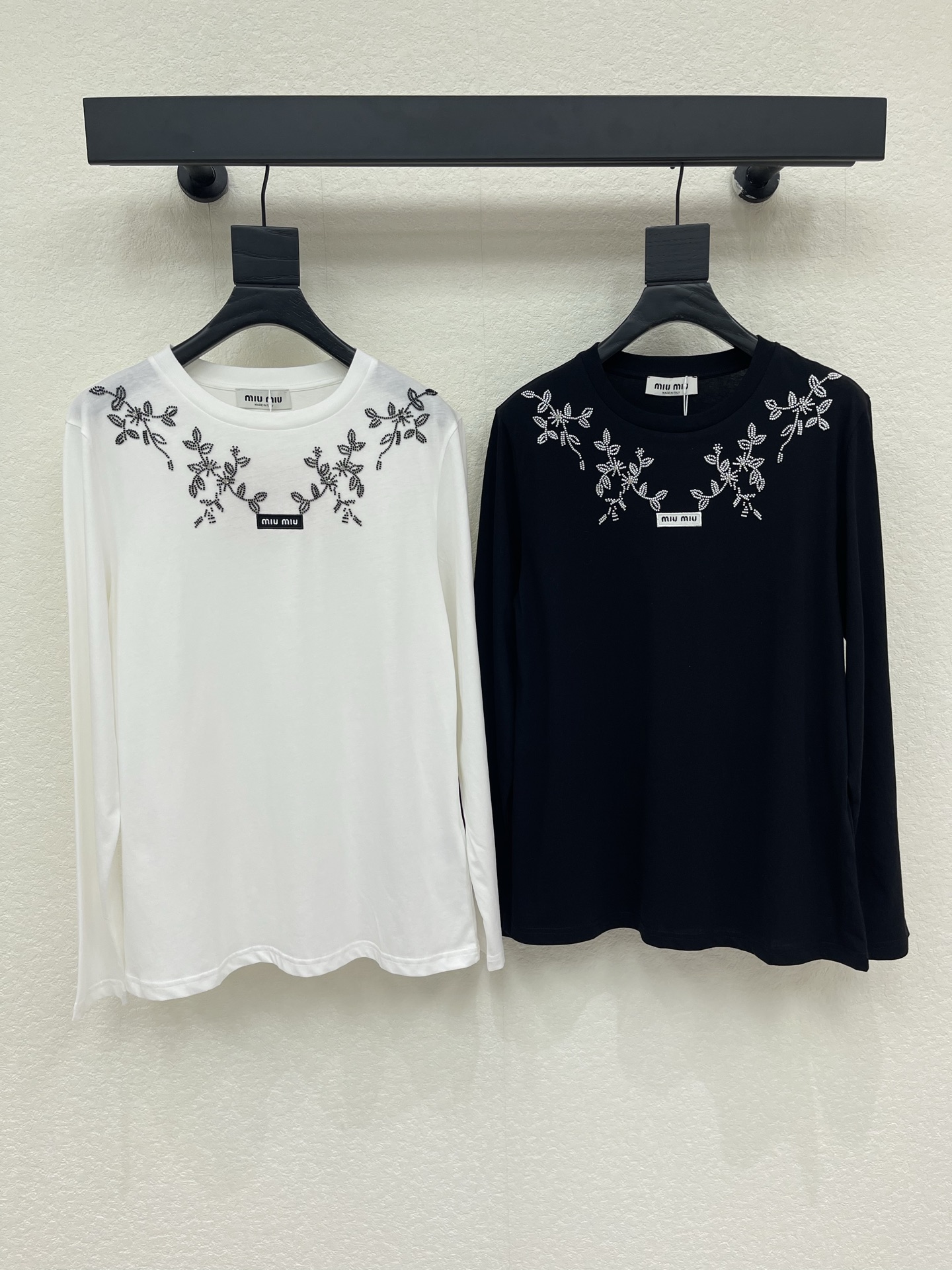 NO:950299,Miumi*26 early autumn new three-dimensional beaded logo embroidered round neck long-sleeved T-shirt. Black and white two-color classic and durable, soft and skin-friendly fabrics are selected, comfortable and light to wear. The neckline is exquisitely embroidered with vine flower beading, smart and elegant, with a girly atmosphere. Woven punctuation on the chest  It is embellished with the brand logo and has exquisite details. It has a simple round neck fit and neat long sleeves that modify the arm lines. It is gentle and colorful when worn alone, and it is also suitable for layering jackets, perfectly presenting the elegant and sweet retro girl style. SML,, miumiu, jackets  & coats,tees,t-shirt,19860909Miumi*26早秋新款立体钉珠徽标刺绣圆领长袖T恤.黑白双色经典耐看,甄选软糯亲肤面料,穿着舒适轻盈.领口精致藤蔓花卉钉珠刺绣,灵动雅致,自带少女氛围感.胸前织标点缀品牌标识,细节考究.简约圆领合身版型,利落长袖修饰手臂线条.单穿温柔出彩,叠搭外套亦很适配,将优雅甜美的复古少女格调完美呈现.SML,,miumiu,jackets & coats,tees，t-shirt,,Women's clothing