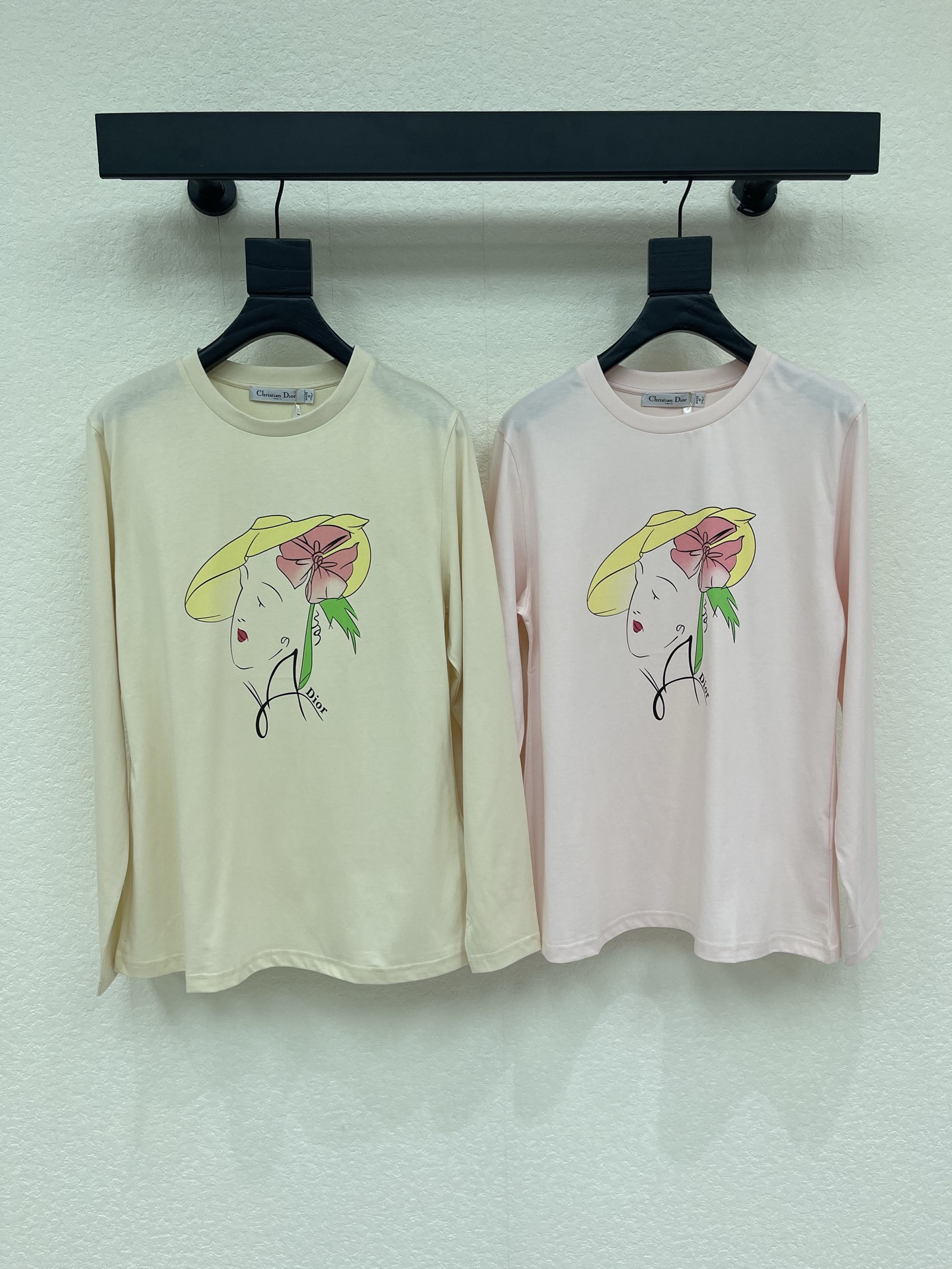 NO:950285,Dio*26 early autumn new hat flower portrait print long-sleeved T-shirt. Soft milky apricot and light pink two-tone, the fabric is delicate and soft, the upper body is light and comfortable. The body of the dress is artistically hand-painted girly print, the lines are smart and vivid, and it is matched with the brand's handwritten logo, full of French literary atmosphere  .Simple round neck with fitted long sleeves, a neat and versatile silhouette. It can be worn alone or as an inner layer. It has a gentle atmosphere and artistic style, and can easily create a relaxed and elegant daily look. SML, dior, tees, t-shirt, hats,19860909Dio*26早秋新款帽子花朵人像印花长袖T恤.柔和奶杏、浅粉双色调,面料细腻柔软,上身轻盈舒适.衣身艺术手绘少女印花,线条灵动鲜活,搭配品牌手写标识,充满法式文艺气息.简约圆领搭配合身长袖,版型利落百搭.可单穿或作为内搭,兼具温柔氛围感与艺术格调,轻松打造松弛雅致的日常造型.SML,,dior,tees，t-shirt,hats,,Women's clothing