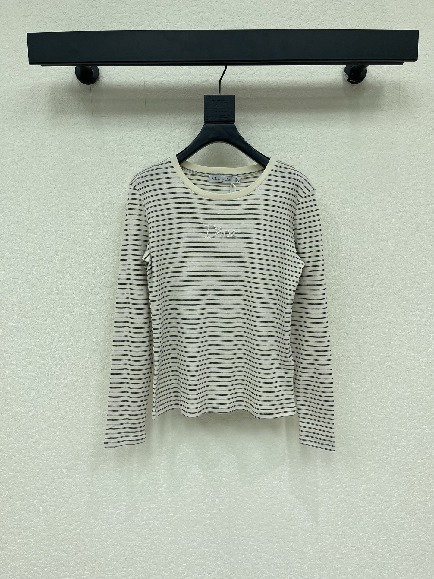NO:950271,Dio*26 new early autumn contrasting striped long-sleeved bottoming T-shirt. Classic beige and gray pinstripes, with a French relaxed atmosphere. Soft skin-friendly knitted fabric, warm and breathable to the touch. The three-dimensional embroidered logo on the chest is low-key and simple, unobtrusive but highly recognizable. The round-neck short version cleverly raises the waistline, and the long-sleeved tailoring modifies the arm lines. It can be worn alone or as an inner layer, suitable for skirts and jeans, and can easily create a simple, durable, low-key and luxurious daily wear.  SML,,dior,skirts,jeans,tees,t-shirt,19860909Dio*26早秋新款撞色条纹长袖打底T恤衫.经典米灰细条纹,自带法式松弛氛围感.柔软亲肤针织面料,触感温润透气.胸前立体刺绣logo低调简约,不张扬却极具辨识度.圆领短款版型巧妙拉高腰线,长袖剪裁修饰手臂线条.可单穿也可作为内搭,适配半裙、牛仔裤,轻松演绎简约耐看、低调显贵的日常轻奢穿搭. SML,,dior,skirts,jeans,tees，t-shirt,,Women's clothing