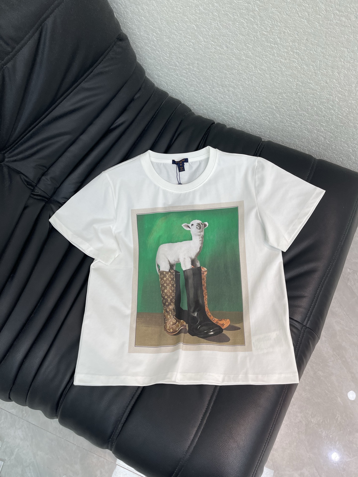 NO:953260,Louis Vuitto*26 new product, white round neck short-sleeved T-shirt, printed on the front is the pattern of a lamb wearing rain boots from the 'Super Nature' series - the lamb is standing in front of a green background, wearing a pair of LV Monogram pattern rain boots, which is quite interesting and surreal style. It has a loose fit and can be worn by both men and women. There are several directions for matching. You can refer to black straight-leg pants or wide-leg pants. It is clean and neat, and the pattern is the visual focus. Pair it with jeans + white shoes, which is more casual for daily life.  Wear shirts as base layers for a more layered look!  SML,,louis vuitton,louis vuitton,boots,rain boots,jeans,shirts,T-shirt,tees,t-shirt,19860909Louis Vuitto*26新品 白色圆领短袖T恤,正面印的是' Super Nature '系列里的小羊穿雨靴图案——小羊站在绿色背景前,脚踩一双 LV Monogram 花纹雨靴,挺有意思的超现实风格.宽松版型,男女都能穿.搭配上有几个方向可以参考搭黑色直筒裤或阔腿裤,干净利落,图案是视觉焦点就够了 搭牛仔裤 + 白鞋,偏日常休闲 叠穿衬衫打底,更有层次感！SML,,louis vuitton,louis vuitton,boots,rain boots,jeans,shirts,T-shirt,tees，t-shirt,,Women's clothing