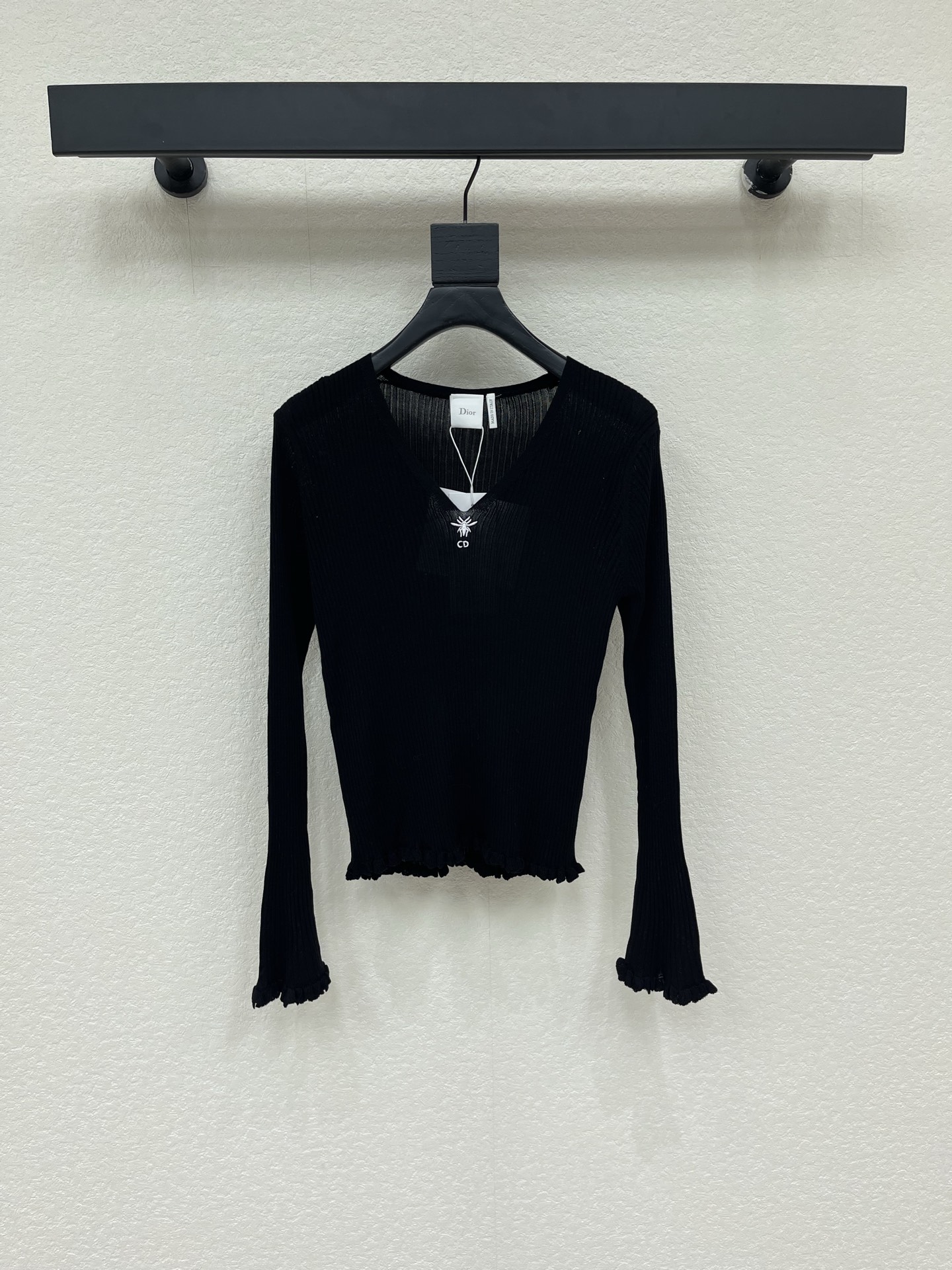 NO:957698,Dio*26 new early autumn bee embroidery V-neck pit strips and ear-edged bell-sleeved knitted tops, classic pure black color, slim and versatile, slim vertical pit strip weave, with elasticity, outlines a beautiful body shape, neat V-neck to modify the neck line, exquisite embroidery logo embellishment on the chest  , low-key and exquisite, the hem and cuffs are designed with fungus pleats, which gently add a sense of layering. The trumpet long-sleeved version modifies the arm lines and covers the body parts. The short cut raises the waistline. The fabric is light and soft. It can be worn alone or layered. It is suitable for commuting and dating!  SML,,dior,19860909Dio*26早秋新款蜜蜂刺绣V领坑条木耳边喇叭袖针织上衣经典纯黑配色显瘦百搭,修身竖坑条织法,自带弹力,勾勒优美身形,利落V领修饰颈部线条,胸口精致刺绣标识点缀,低调精致,下摆与袖口搭配木耳边褶皱设计,温柔增添层次感,喇叭长袖版型,修饰手臂线条,遮住拜拜肉,短款剪裁拉高腰线,面料轻薄柔软,可单穿可内搭,通勤约会都适配！SML,,dior,,Women's clothing