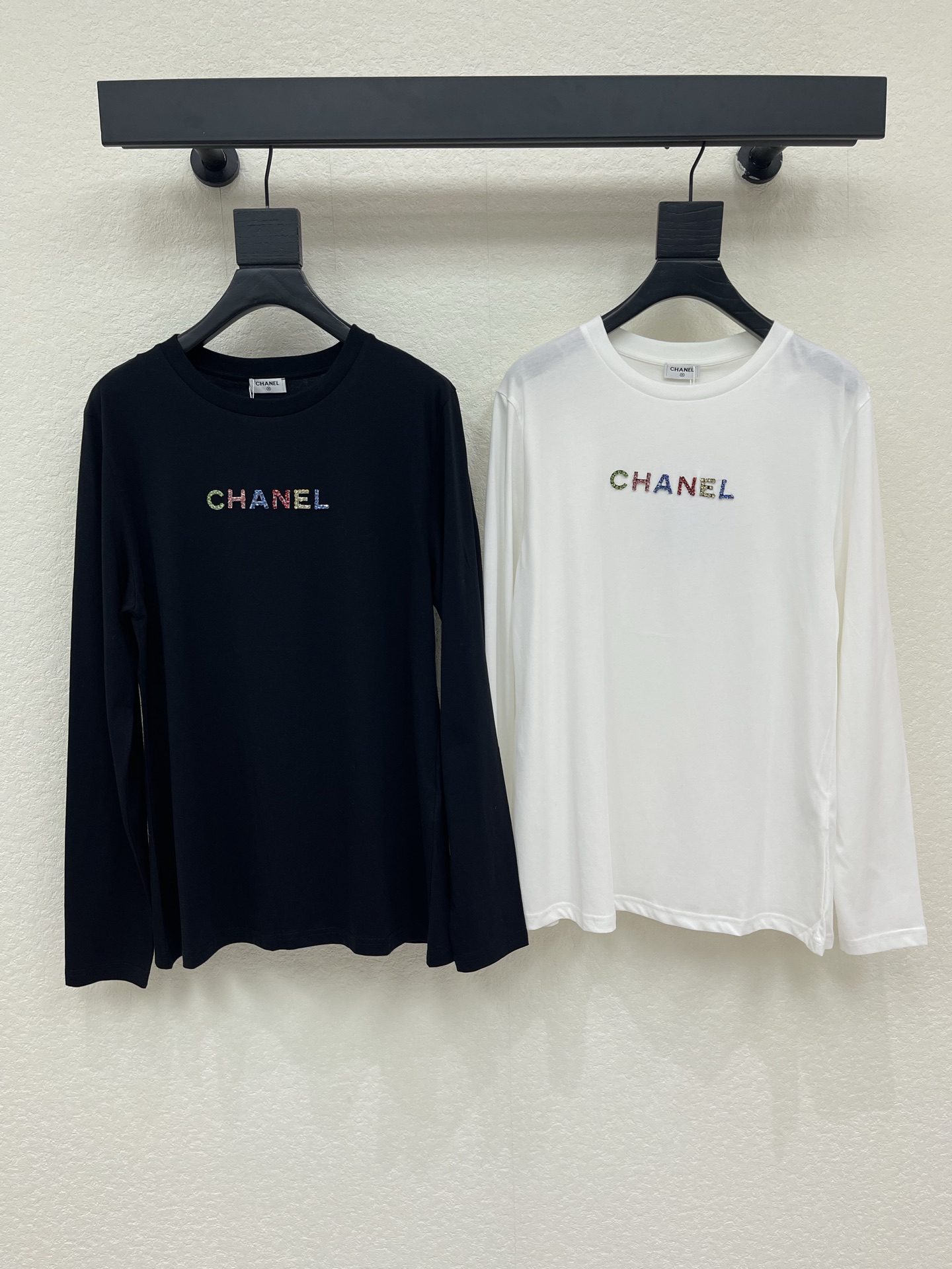 NO:958719,Chane*26 early autumn new heavy industry color stud round neck long-sleeved T-shirt  We select soft, waxy and skin-friendly cotton fabrics. The silhouette is neat and slim but not tight, and the round neck line fits the neck without being cramped. Colored diamonds are used to create exquisite brand words on the chest. The craftsmanship is exquisite and recognizable. The black and white colors are classic and versatile. It comes in multiple sizes to suit various body shapes. It can be worn alone or as an inner layer. It integrates low-key and luxurious French elegance into various daily wear scenarios. SML,, chanel, tees, t-shirt,19860909Chane*26早秋新款重工彩色钉钻圆领长袖T恤 甄选软糯亲肤的棉质面料,版型利落修身不紧绷,圆领线条贴合脖颈不显局促.胸前以彩钻打造精致品牌字样,工艺细腻很有辨识度,黑白两色经典百搭.分多码适配多样身形,单穿、做内搭皆出彩,把低调奢华的法式优雅,融进日常各类穿搭场景.SML,,chanel,tees，t-shirt,,Women's clothing
