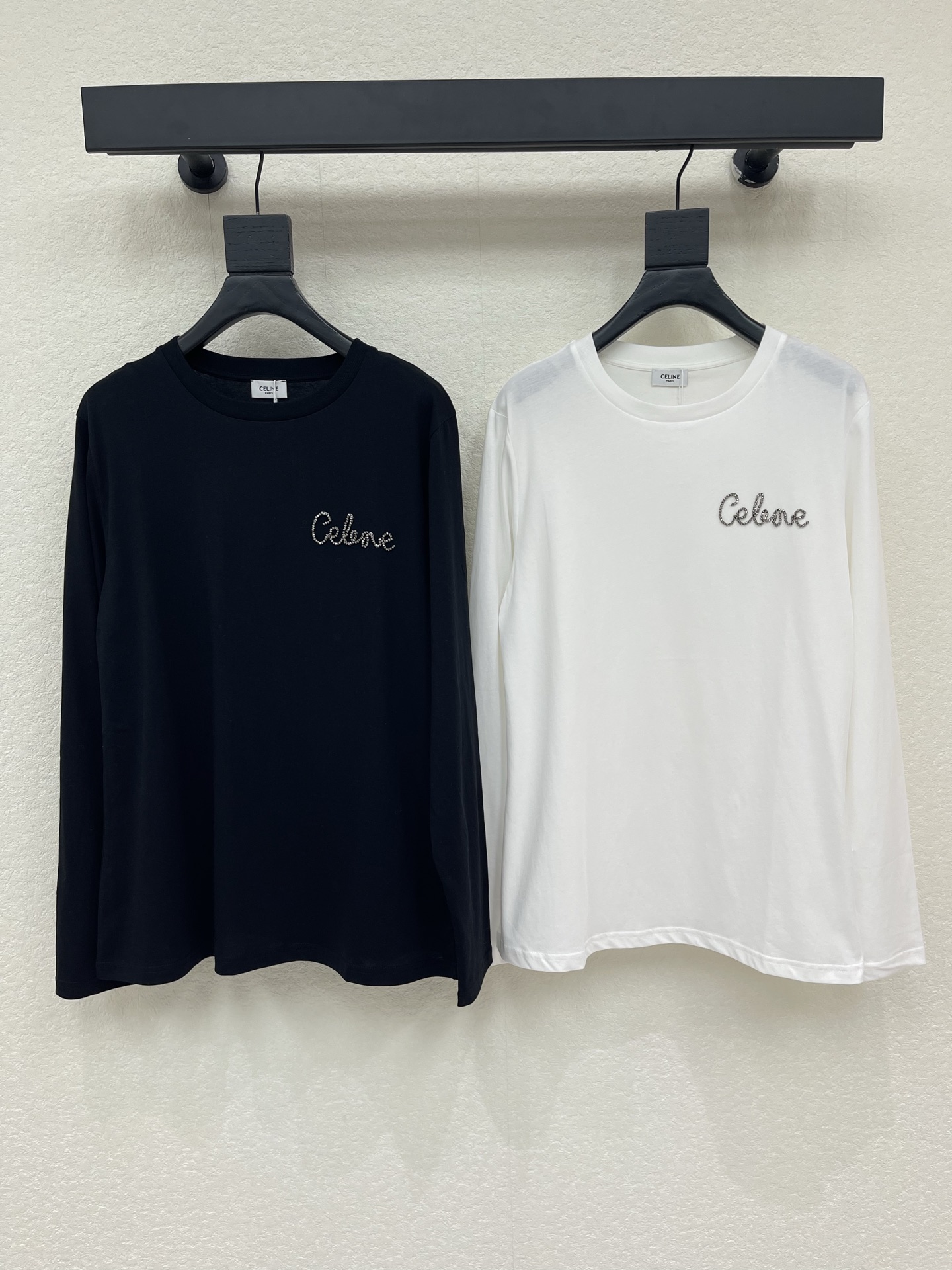 NO:958712,Celin*26 new spring and summer heavy industry studded round neck long-sleeved T-shirt  We select soft, waxy and skin-friendly cotton fabrics. The silhouette is neat and slim but not tight. The round neck line fits the neck without being cramped. The exquisite brand name is created with studs on the chest. The craftsmanship is exquisite and recognizable. The black and white colors are classic and versatile. It comes in multiple sizes to suit various body shapes. It can be worn alone or as an inner layer. It integrates low-key and luxurious French elegance into various daily wear scenarios. SML,, celine, tees, t-shirt,19860909Celin*26春夏新品重工钉钻圆领长袖T恤 甄选软糯亲肤的棉质面料,版型利落修身不紧绷,圆领线条贴合脖颈不显局促.胸前以钉钻打造精致品牌字样,工艺细腻很有辨识度,黑白两色经典百搭.分多码适配多样身形,单穿、做内搭皆出彩,把低调奢华的法式优雅,融进日常各类穿搭场景.SML,,celine,tees，t-shirt,,Women's clothing