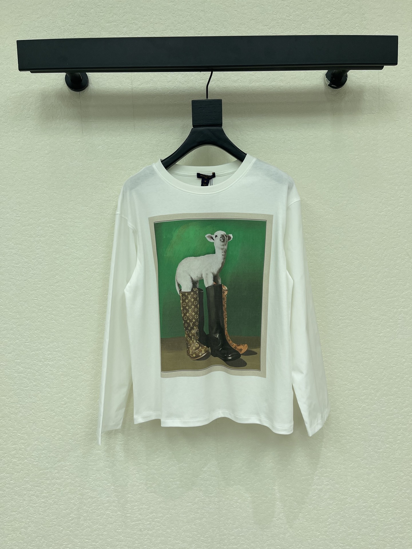 NO:958653,Louis Vuitto*26 new early autumn white round neck printed spliced long-sleeved top, printed on the front is the pattern of a lamb wearing rain boots from the 'Super Nature' series - the lamb is standing in front of a green background, wearing a pair of LV Monogram pattern rain boots, which is quite interesting and surreal style. It has a loose fit and can be worn by both men and women. There are several directions for matching. You can refer to black straight pants or wide-leg pants. It is clean and neat, and the pattern is the visual focus. It is enough to wear jeans + white shoes, which is more casual for daily life.  Wear shirts as base layers for a more layered look!  SML,,louis vuitton,louis vuitton,boots,rain boots,jeans,shirts,19860909Louis Vuitto*26早秋新款白色圆领印花拼接长袖上衣,正面印的是' Super Nature '系列里的小羊穿雨靴图案——小羊站在绿色背景前,脚踩一双 LV Monogram 花纹雨靴,挺有意思的超现实风格.宽松版型,男女都能穿.搭配上有几个方向可以参考搭黑色直筒裤或阔腿裤,干净利落,图案是视觉焦点就够了 搭牛仔裤 + 白鞋,偏日常休闲 叠穿衬衫打底,更有层次感！SML,,louis vuitton,louis vuitton,boots,rain boots,jeans,shirts,,Women's clothing