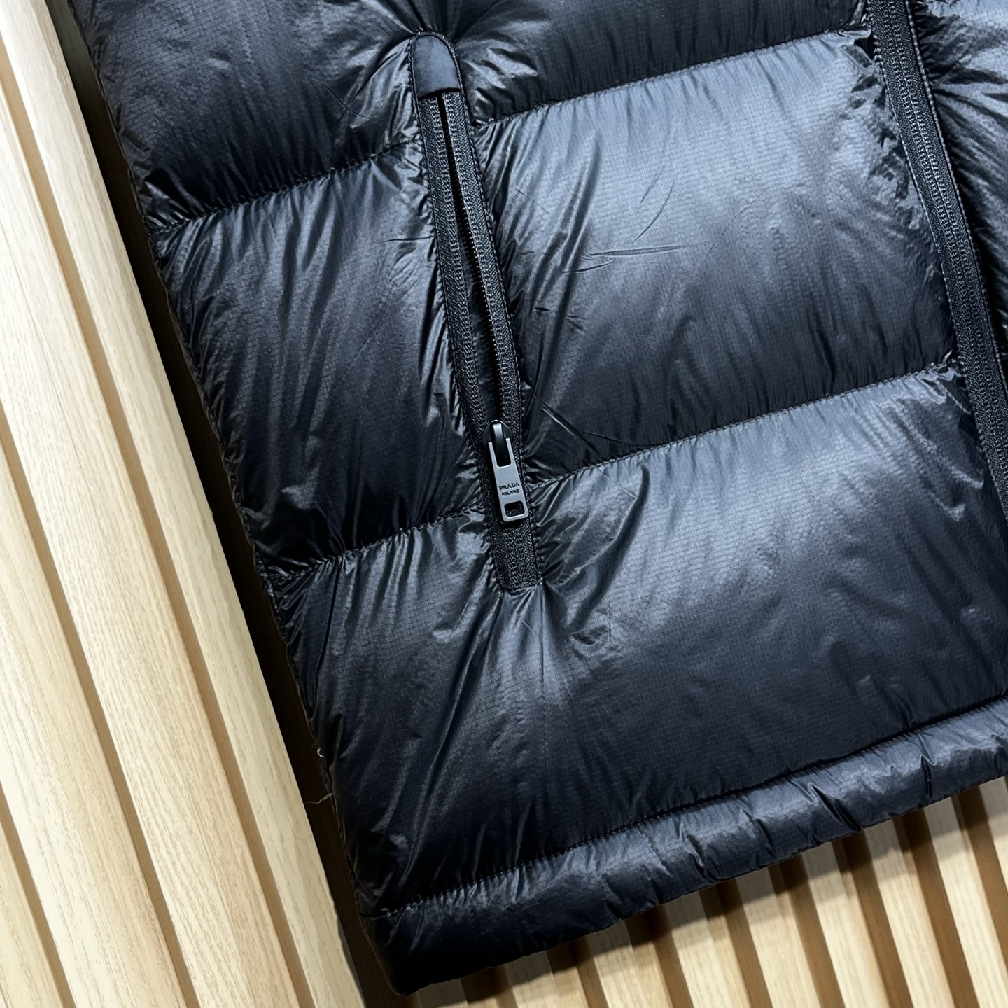 羽绒服 Prada普拉达男士25新款三角标立领尼龙背心羽绒马甲采用立领设计，能有效抵御寒风，提升保暖性。