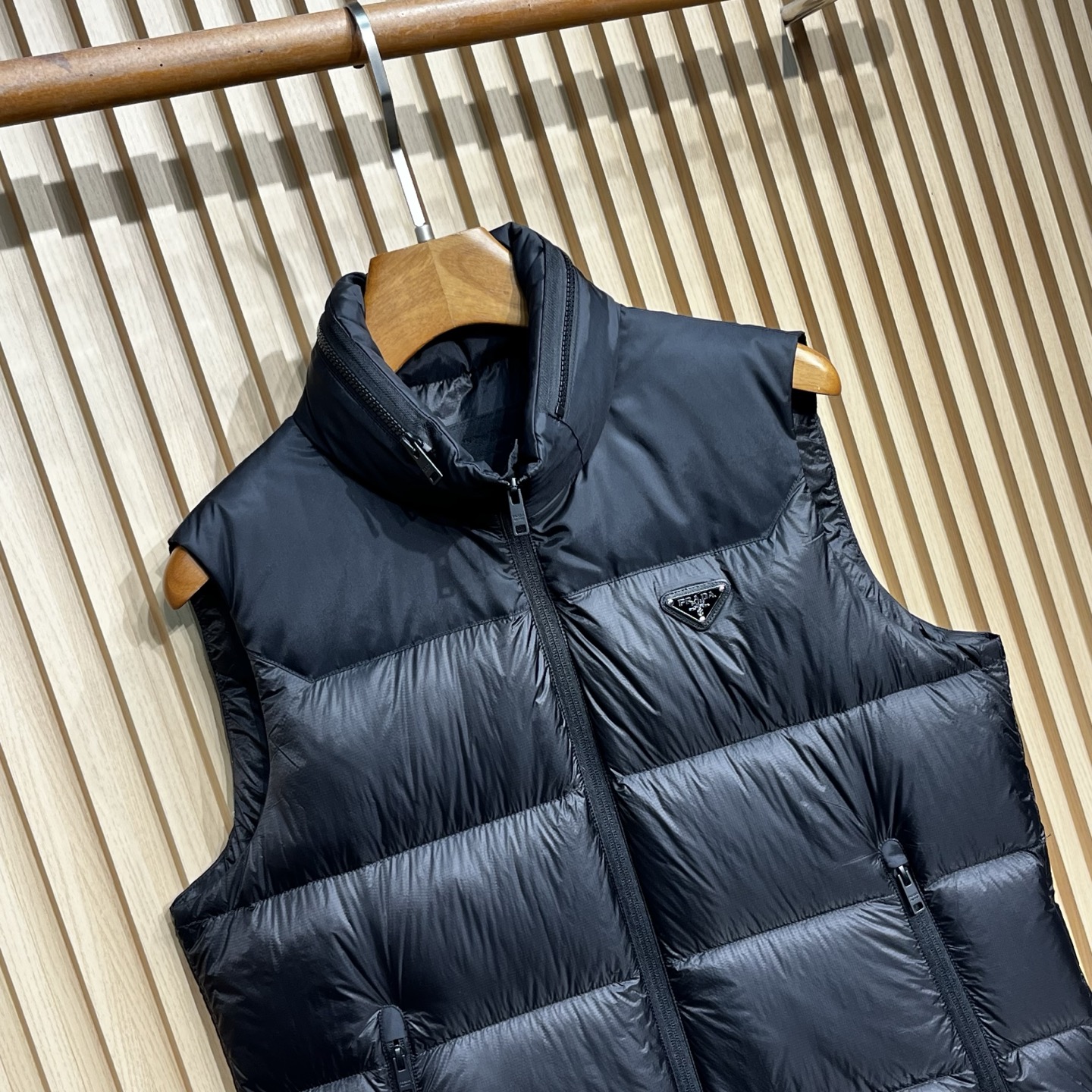 羽绒服 Prada普拉达男士25新款三角标立领尼龙背心羽绒马甲采用立领设计，能有效抵御寒风，提升保暖性。