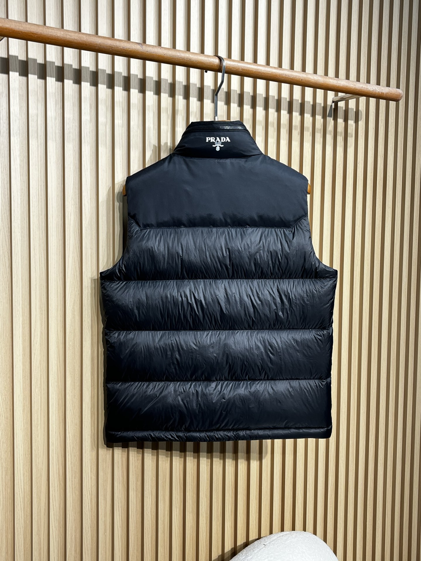 羽绒服 Prada普拉达男士25新款三角标立领尼龙背心羽绒马甲采用立领设计，能有效抵御寒风，提升保暖性。