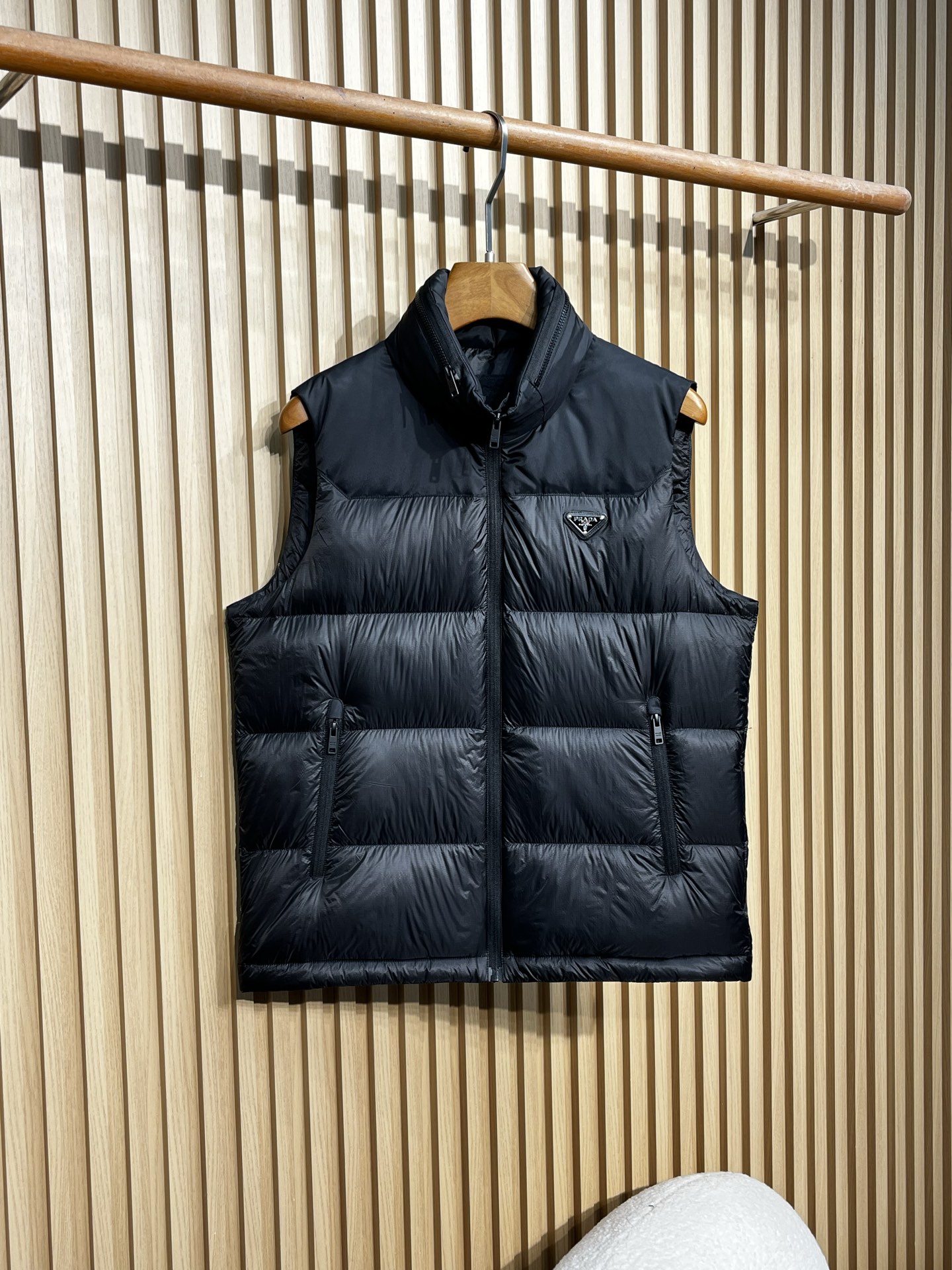 羽绒服 Prada普拉达男士25新款三角标立领尼龙背心羽绒马甲采用立领设计，能有效抵御寒风，提升保暖性。