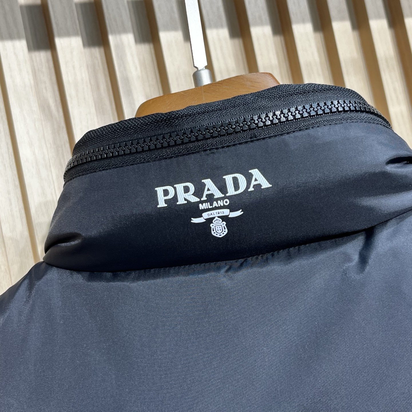 羽绒服 Prada普拉达男士25新款三角标立领尼龙背心羽绒马甲采用立领设计，能有效抵御寒风，提升保暖性。