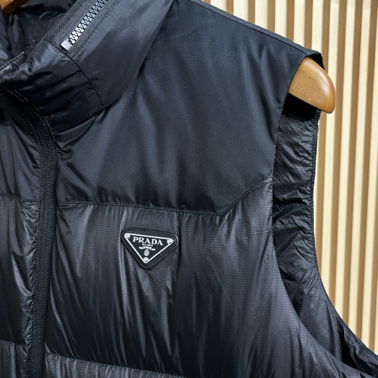 羽绒服 Prada普拉达男士25新款三角标立领尼龙背心羽绒马甲采用立领设计，能有效抵御寒风，提升保暖性。