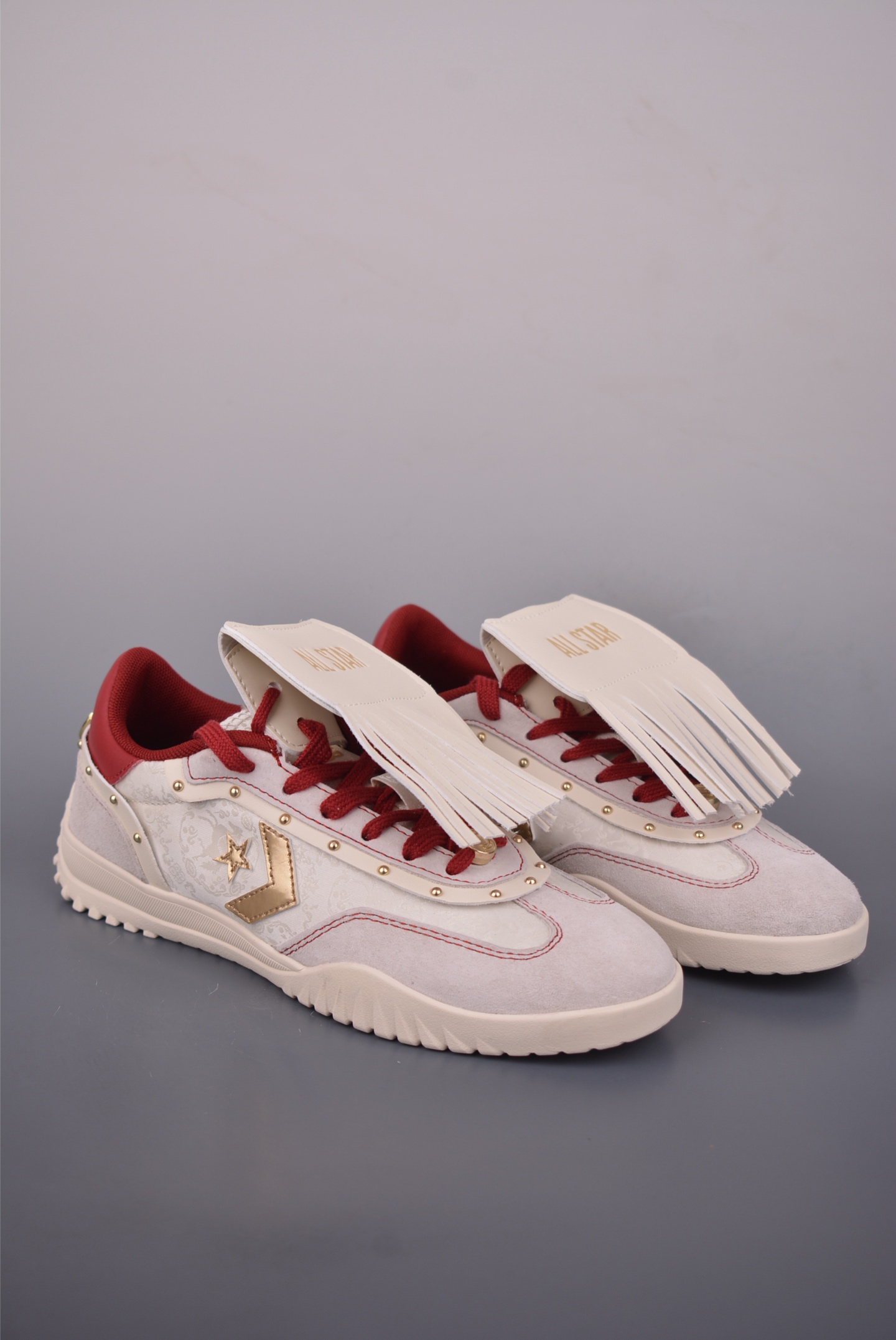 Converse All Star CNY 马年限定 匡威2026马年CNY新年限定德训鞋 米白麂皮搭配酒红内衬,鎏金星箭标搭配流苏装饰直接拉满东方韵味,红白编织鞋带还藏着中式巧思,鞋身的暗纹和金属铆钉质感拉满. 货号:A19073C