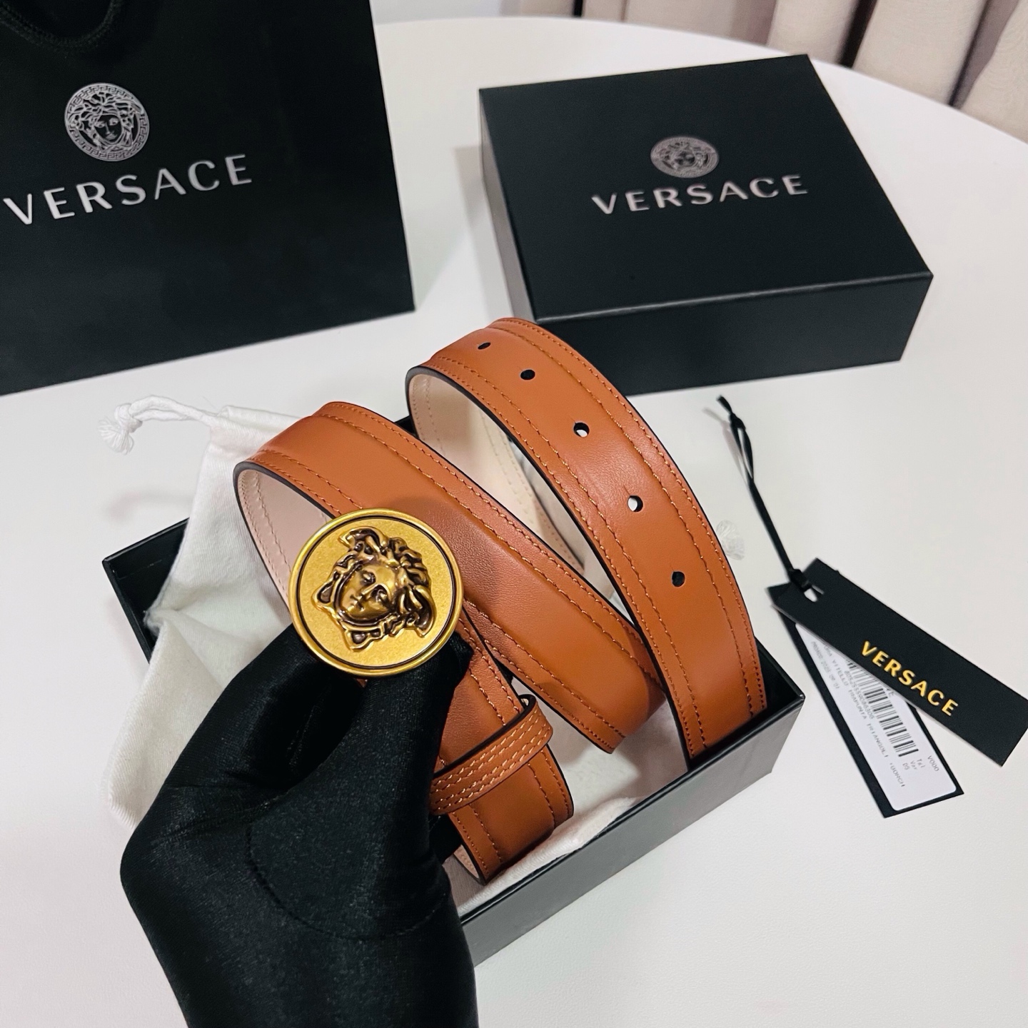 范思哲，新款牛皮革腰带，饰有Versace Logo字样，配有圆形金属搭扣，搭扣采用复古饰面，镶嵌立体M