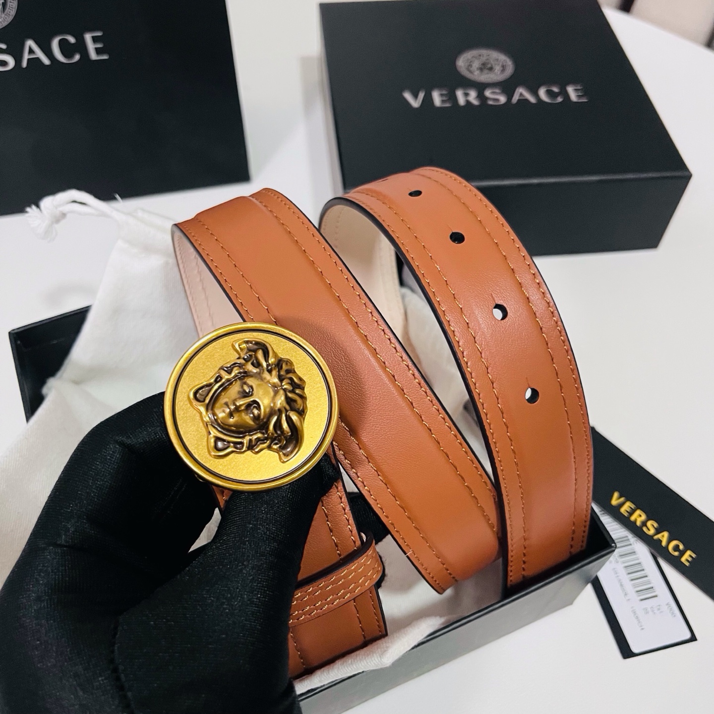 范思哲，新款牛皮革腰带，饰有Versace Logo字样，配有圆形金属搭扣，搭扣采用复古饰面，镶嵌立体M