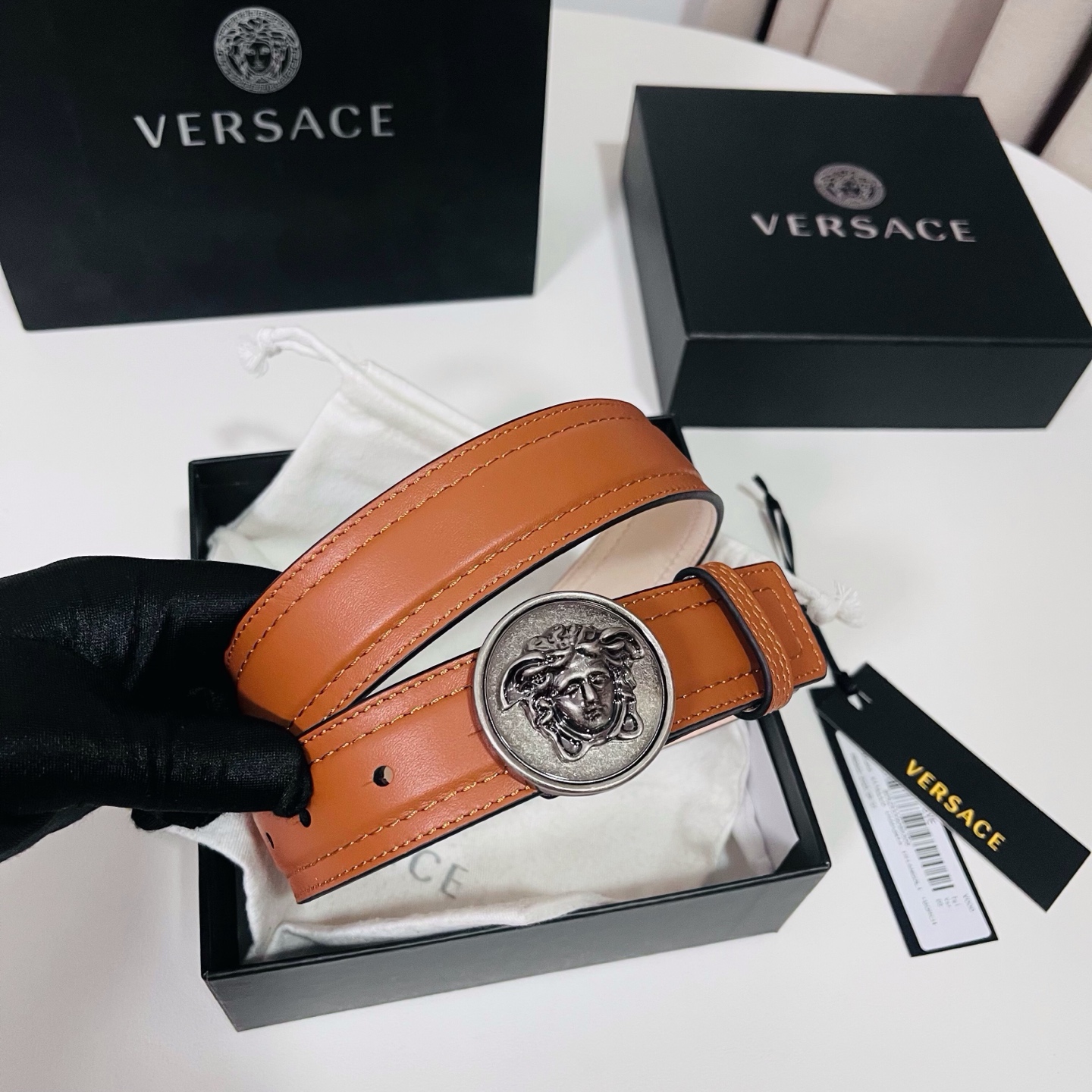 范思哲，新款牛皮革腰带，饰有Versace Logo字样，配有圆形金属搭扣，搭扣采用复古饰面，镶嵌立体M