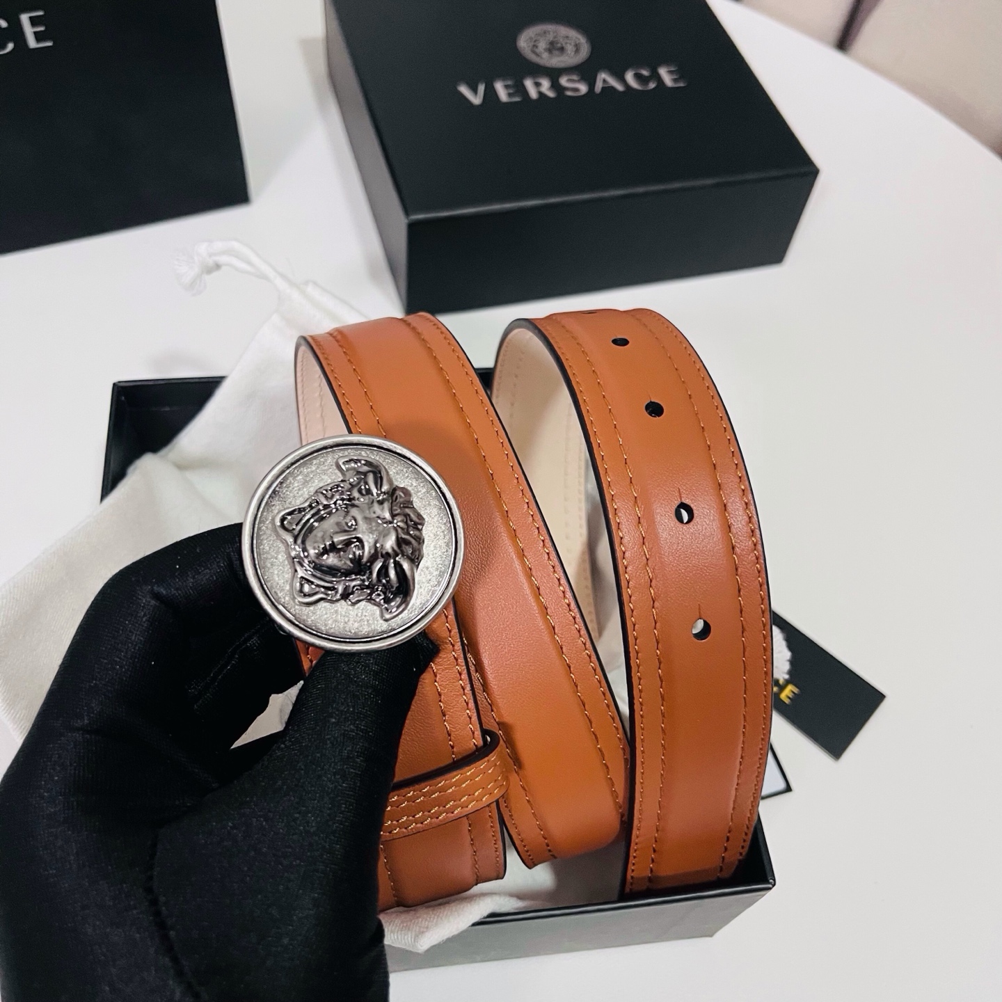 范思哲，新款牛皮革腰带，饰有Versace Logo字样，配有圆形金属搭扣，搭扣采用复古饰面，镶嵌立体M