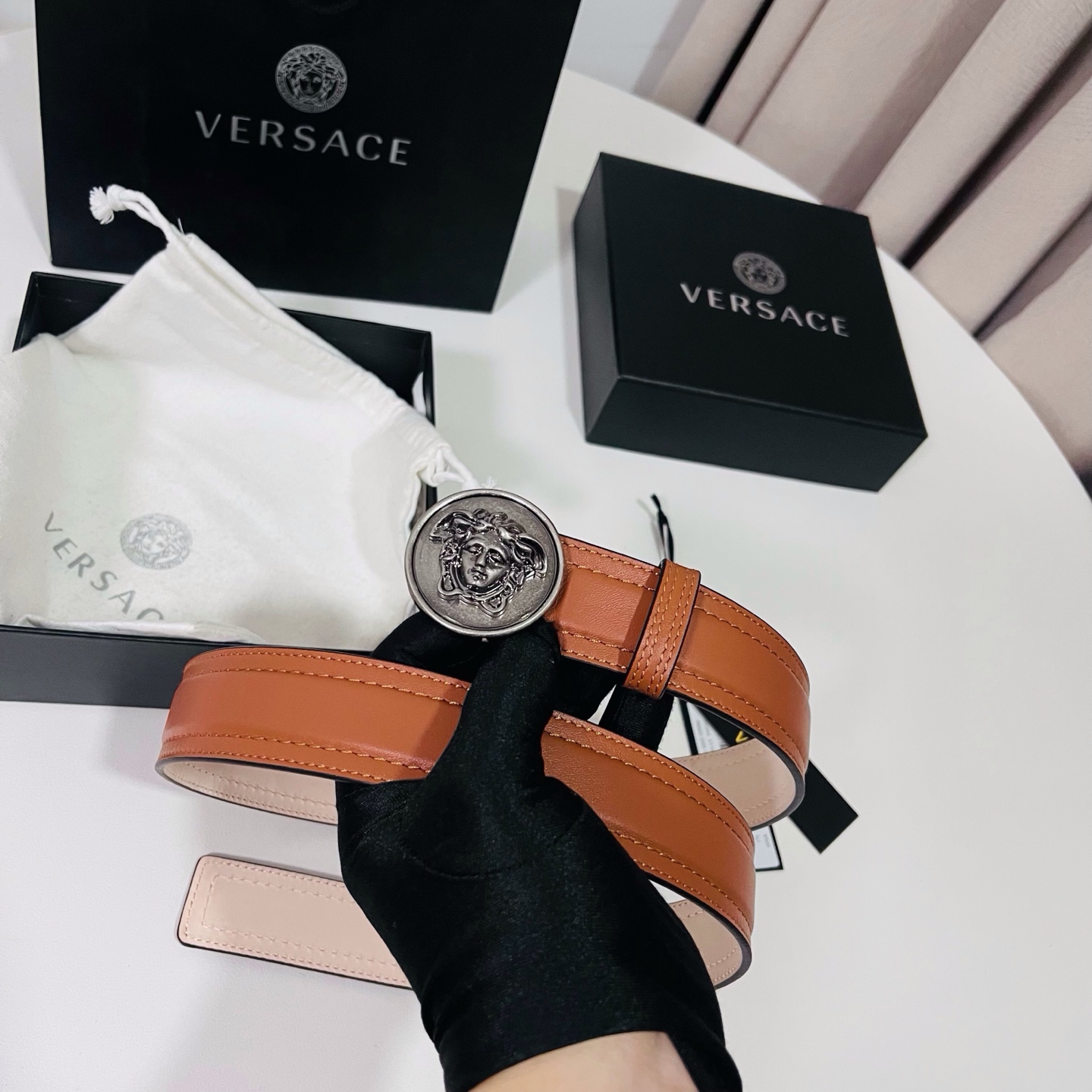 范思哲，新款牛皮革腰带，饰有Versace Logo字样，配有圆形金属搭扣，搭扣采用复古饰面，镶嵌立体M