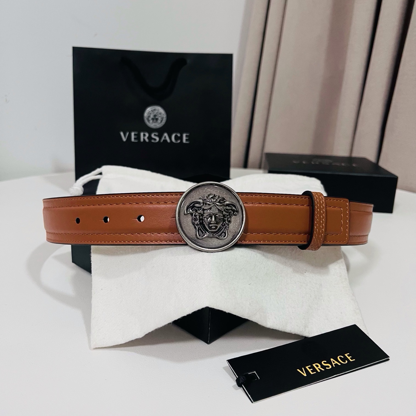 范思哲，新款牛皮革腰带，饰有Versace Logo字样，配有圆形金属搭扣，搭扣采用复古饰面，镶嵌立体M