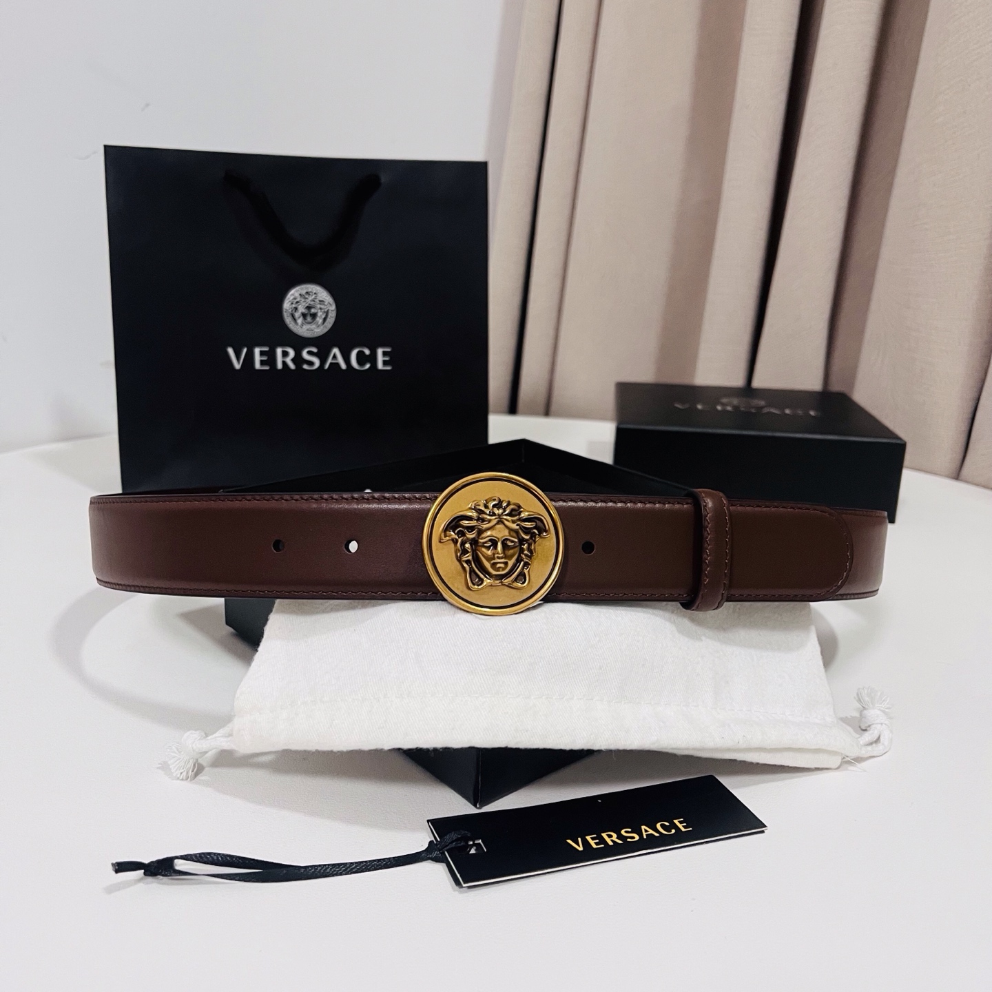 范思哲，新款牛皮革腰带，饰有Versace Logo字样，配有圆形金属搭扣，搭扣采用复古饰面，镶嵌立体M
