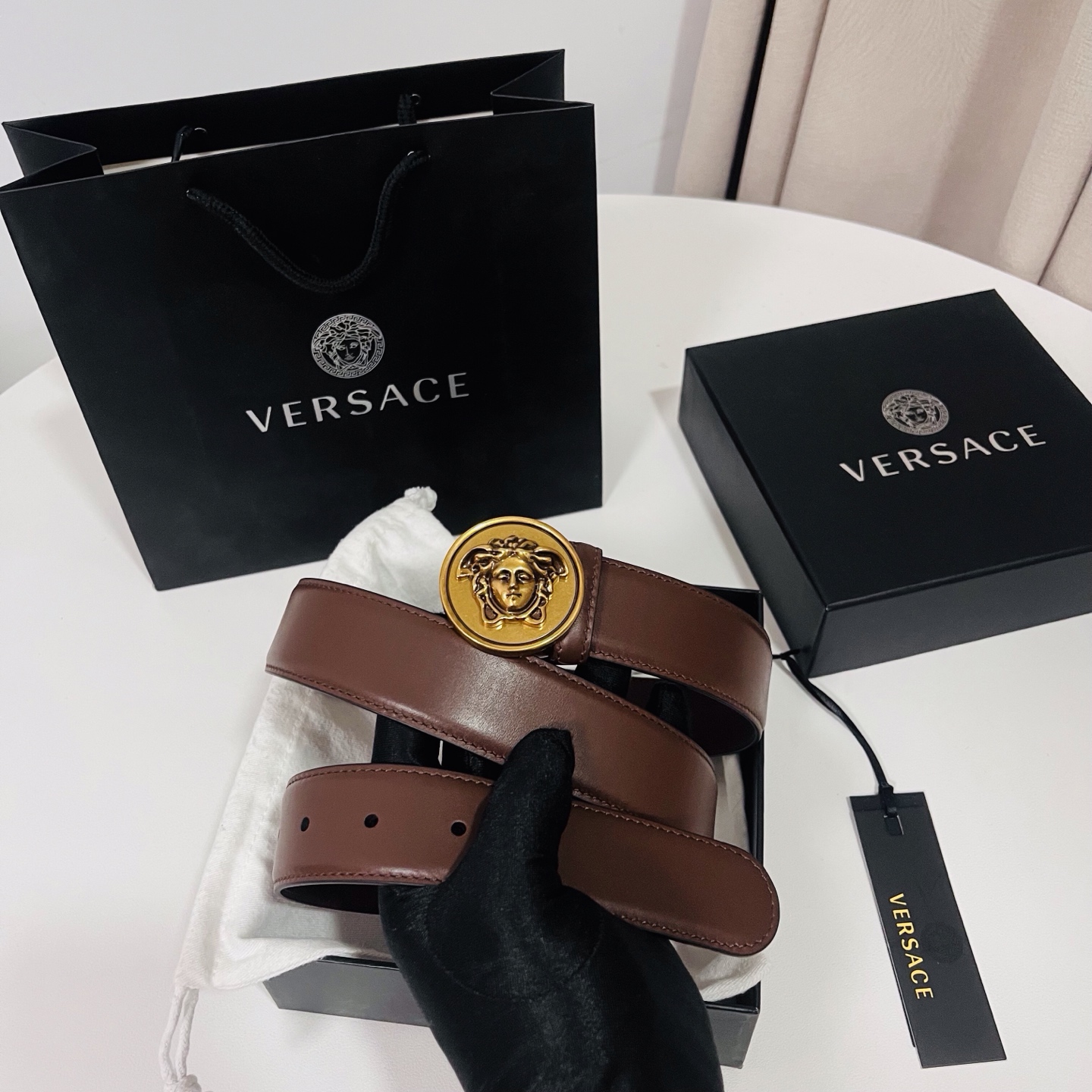 范思哲，新款牛皮革腰带，饰有Versace Logo字样，配有圆形金属搭扣，搭扣采用复古饰面，镶嵌立体M