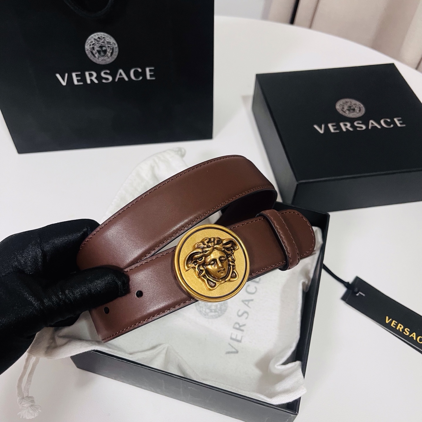范思哲，新款牛皮革腰带，饰有Versace Logo字样，配有圆形金属搭扣，搭扣采用复古饰面，镶嵌立体M