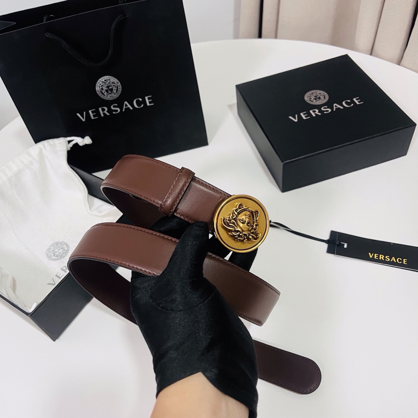 范思哲，新款牛皮革腰带，饰有Versace Logo字样，配有圆形金属搭扣，搭扣采用复古饰面，镶嵌立体M