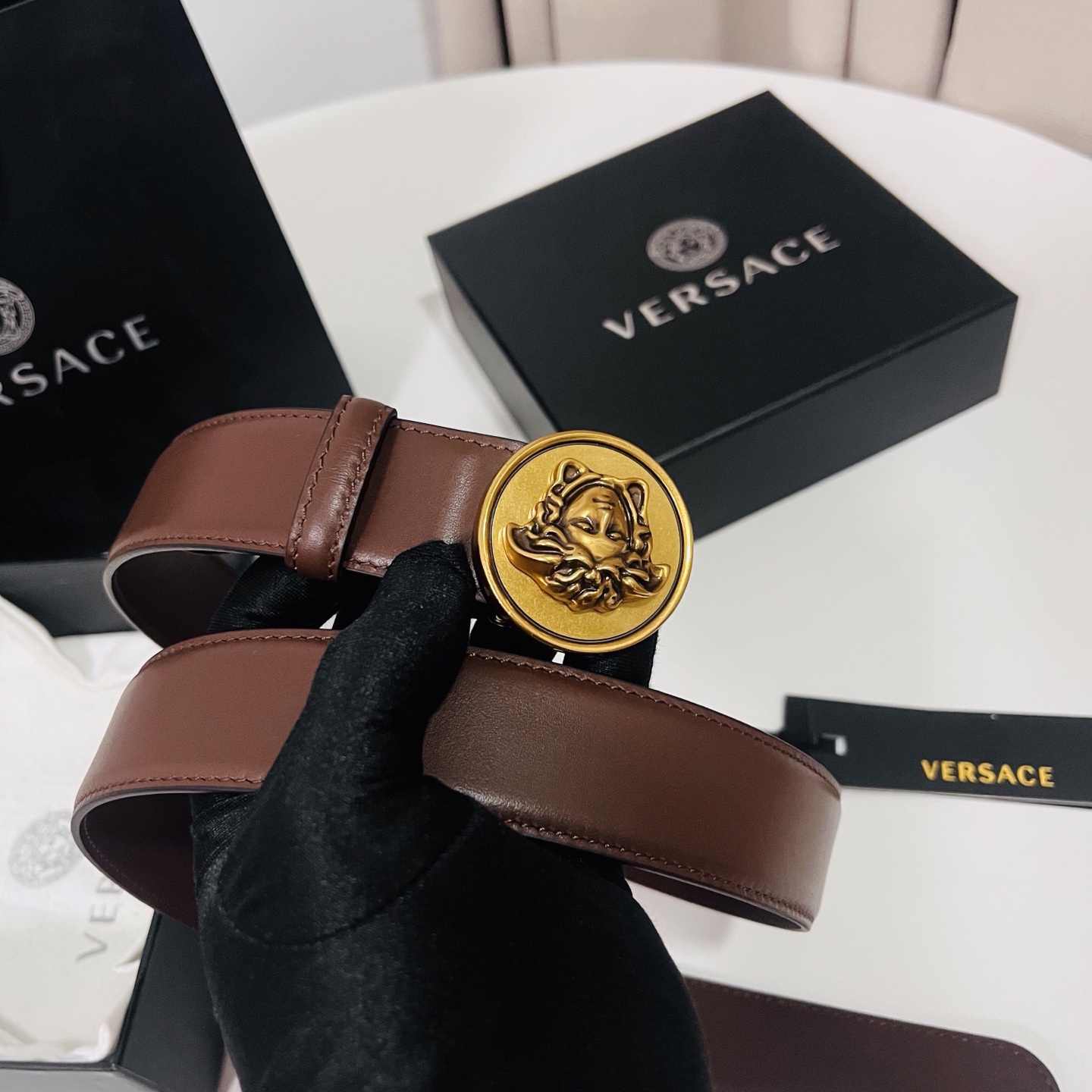 范思哲，新款牛皮革腰带，饰有Versace Logo字样，配有圆形金属搭扣，搭扣采用复古饰面，镶嵌立体M
