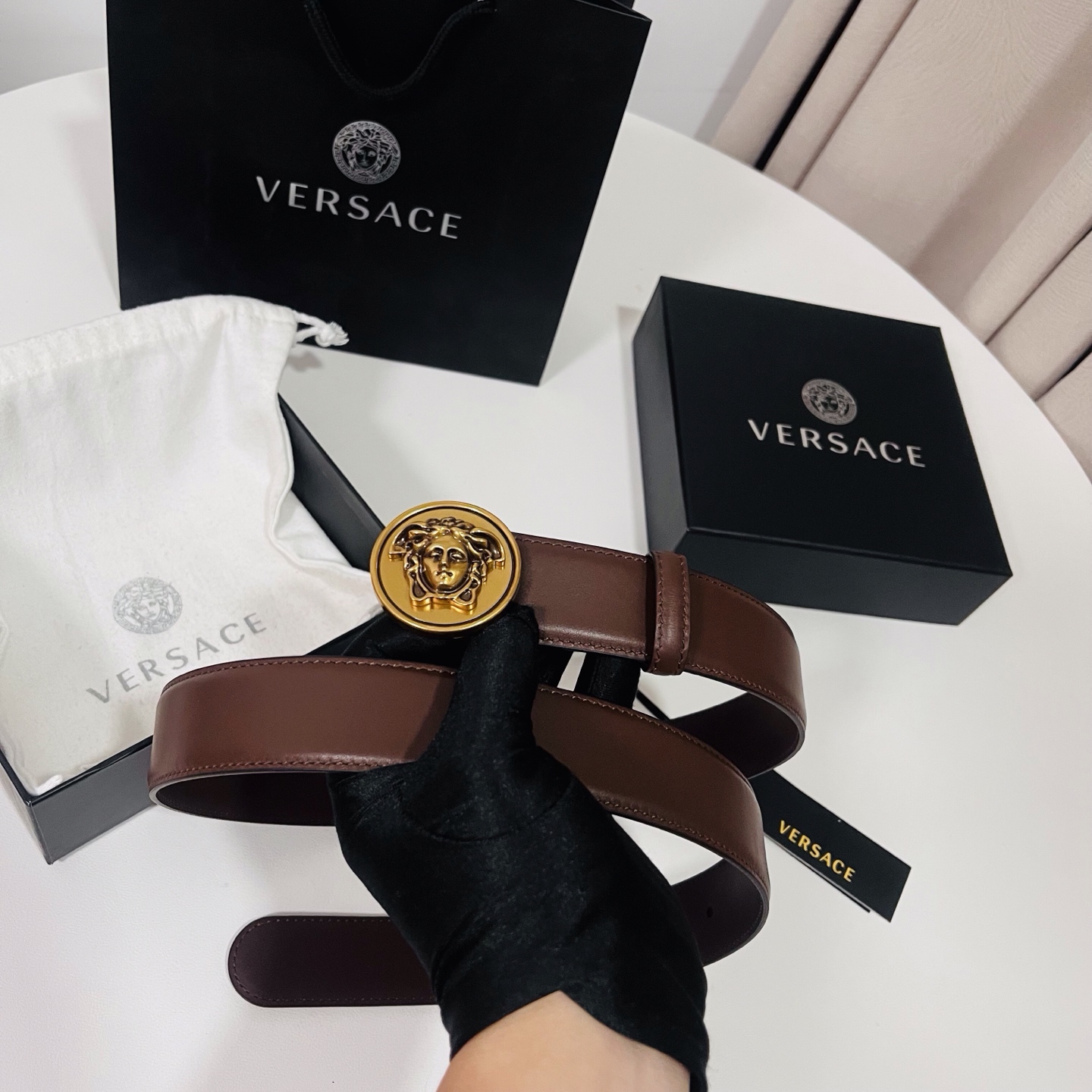 范思哲，新款牛皮革腰带，饰有Versace Logo字样，配有圆形金属搭扣，搭扣采用复古饰面，镶嵌立体M