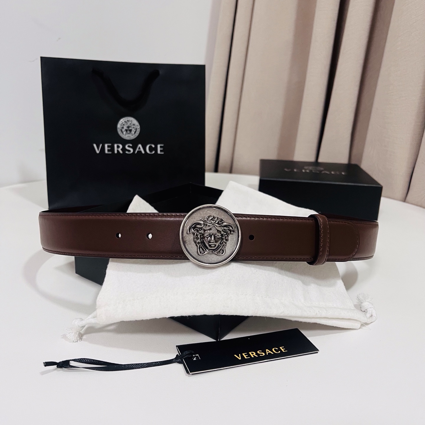 范思哲，新款牛皮革腰带，饰有Versace Logo字样，配有圆形金属搭扣，搭扣采用复古饰面，镶嵌立体M