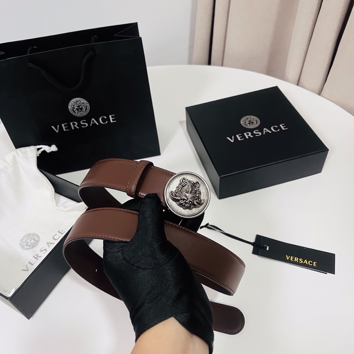 范思哲，新款牛皮革腰带，饰有Versace Logo字样，配有圆形金属搭扣，搭扣采用复古饰面，镶嵌立体M